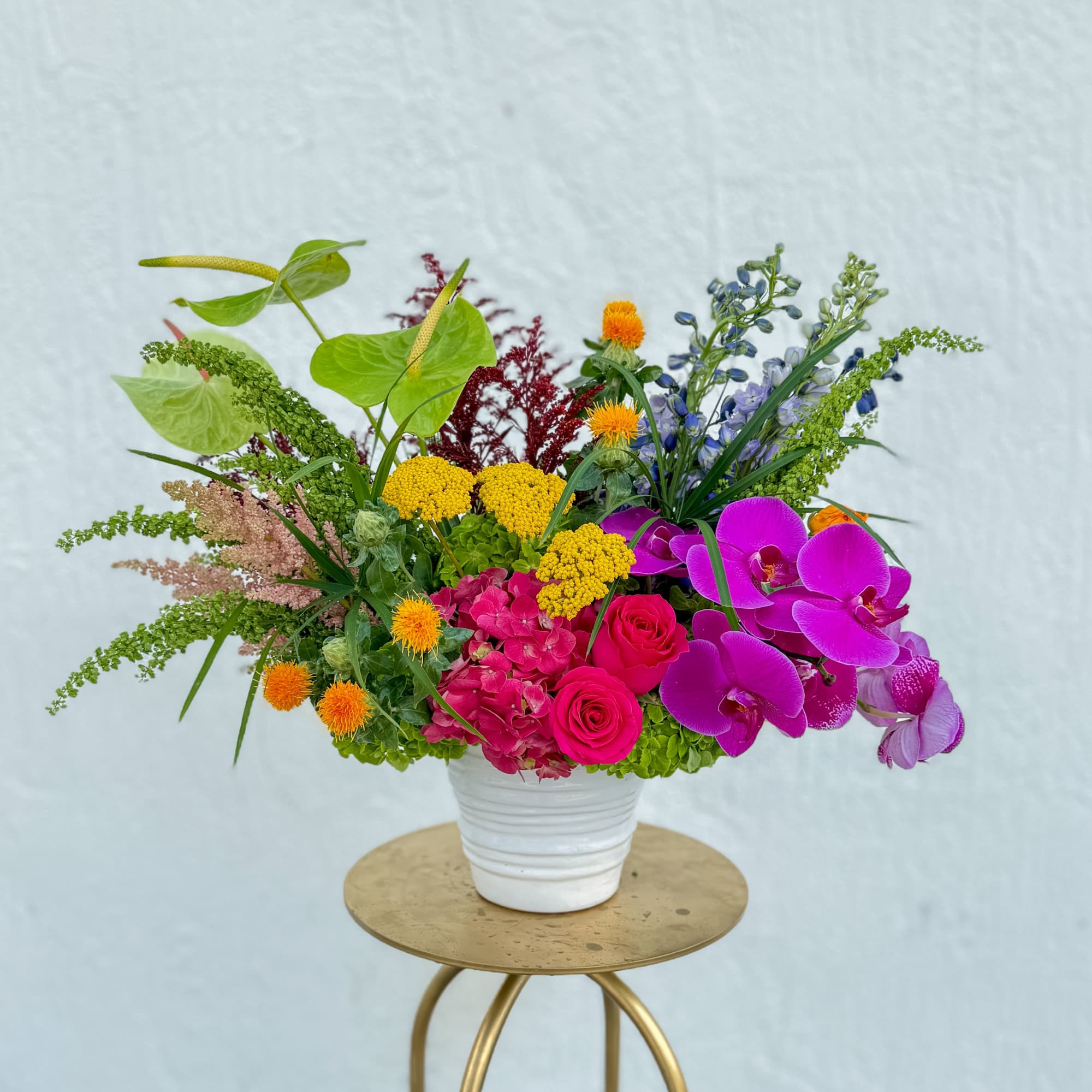 This stunning arrangement captures the warmth and vibrancy of a tropical paradise