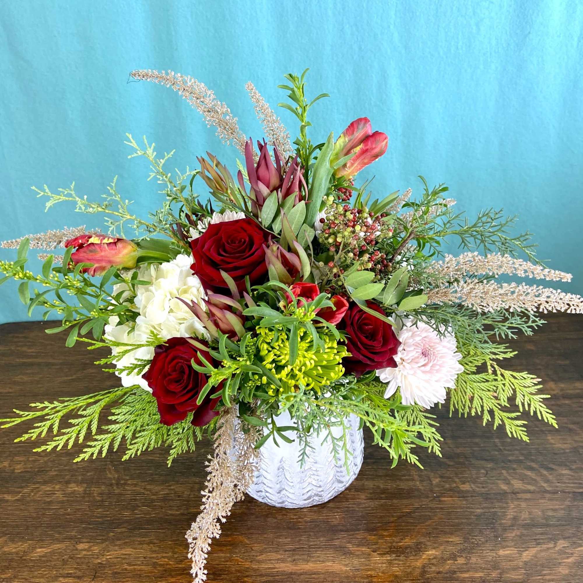 Low floral arrangement in seasonal colors, flowers and greenery.  Will likely