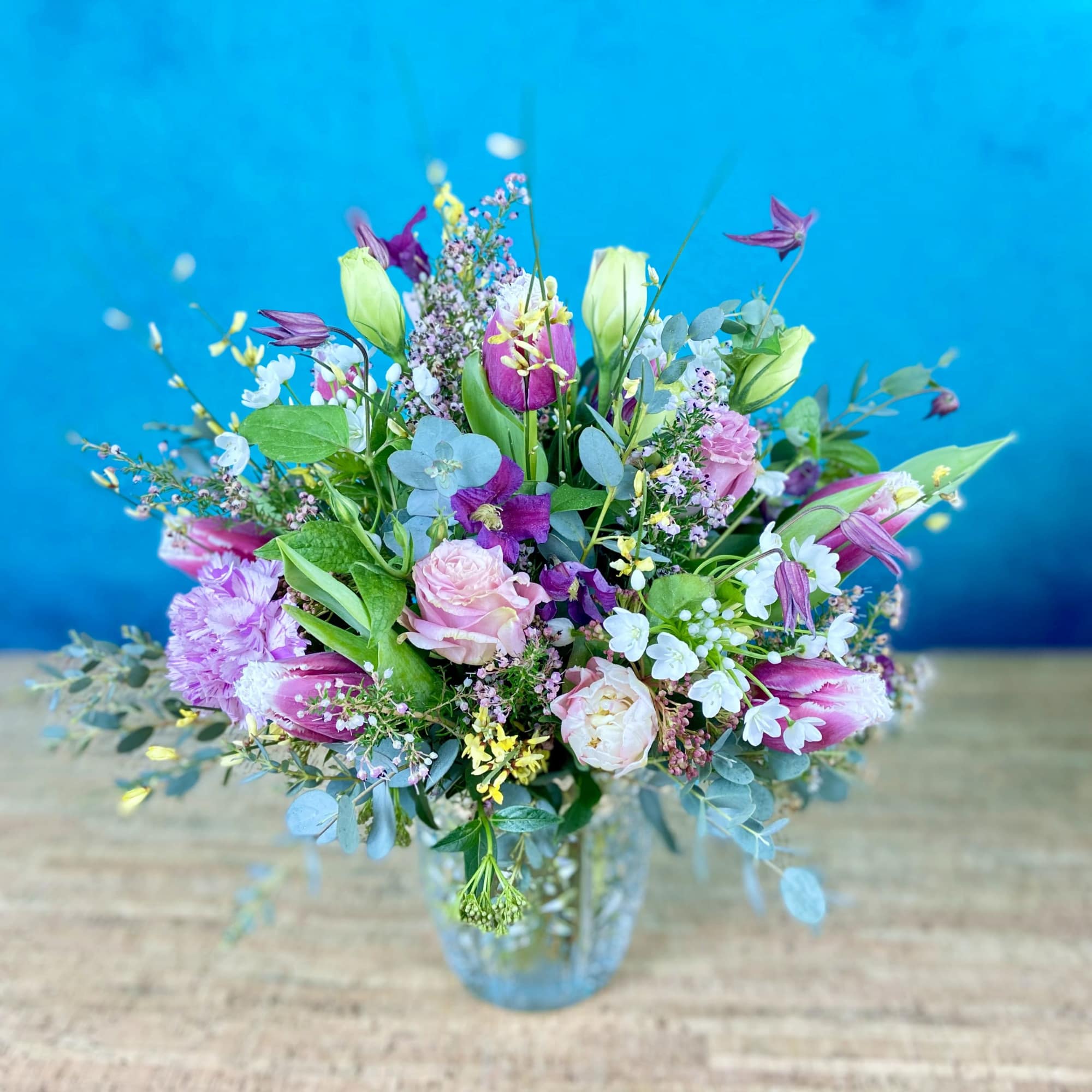 Low floral arrangement in seasonal colors, flowers and greenery.  Will likely