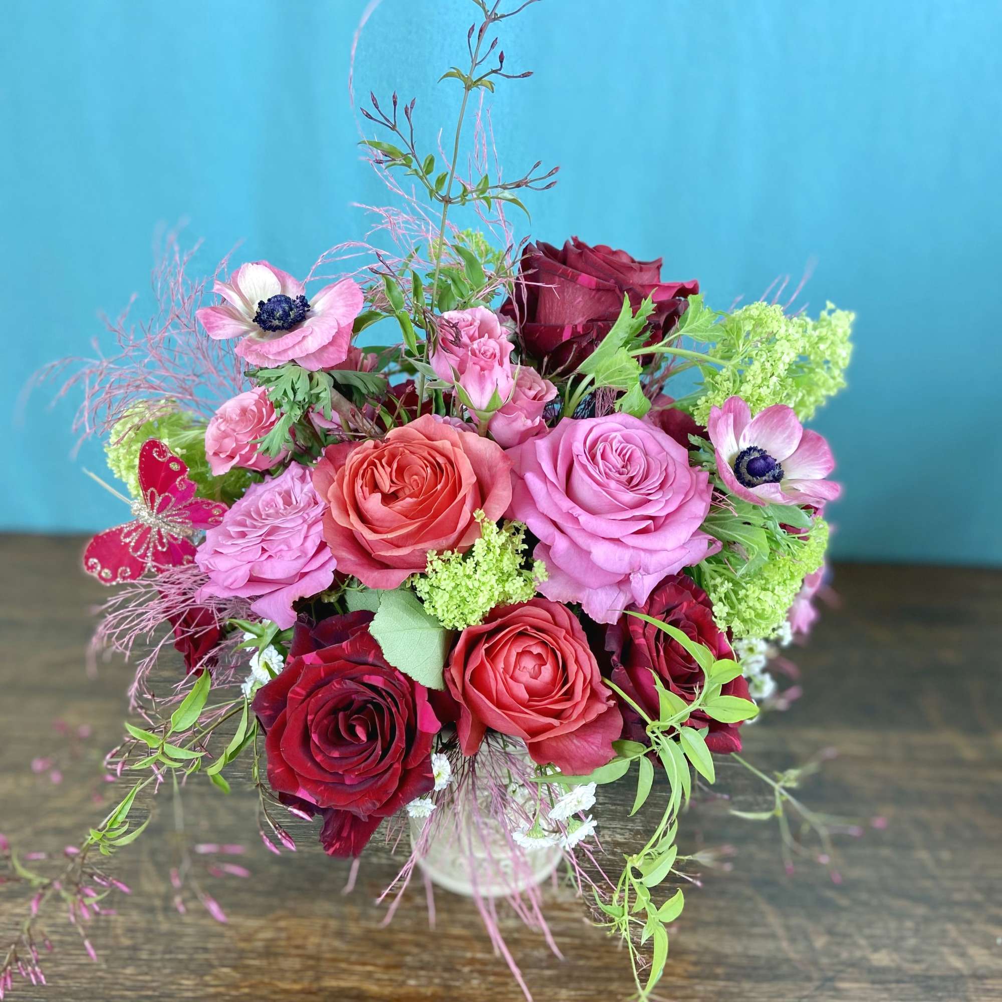 Low floral arrangement in seasonal colors, flowers and greenery.  Will likely