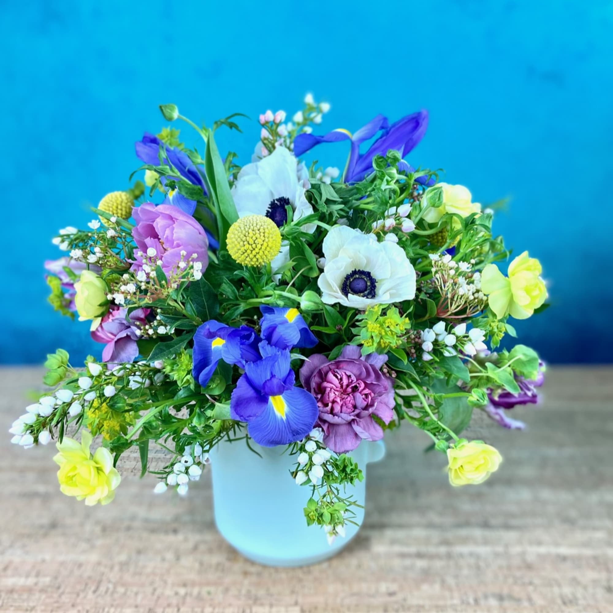 Low floral arrangement in seasonal colors, flowers and greenery.  Will likely