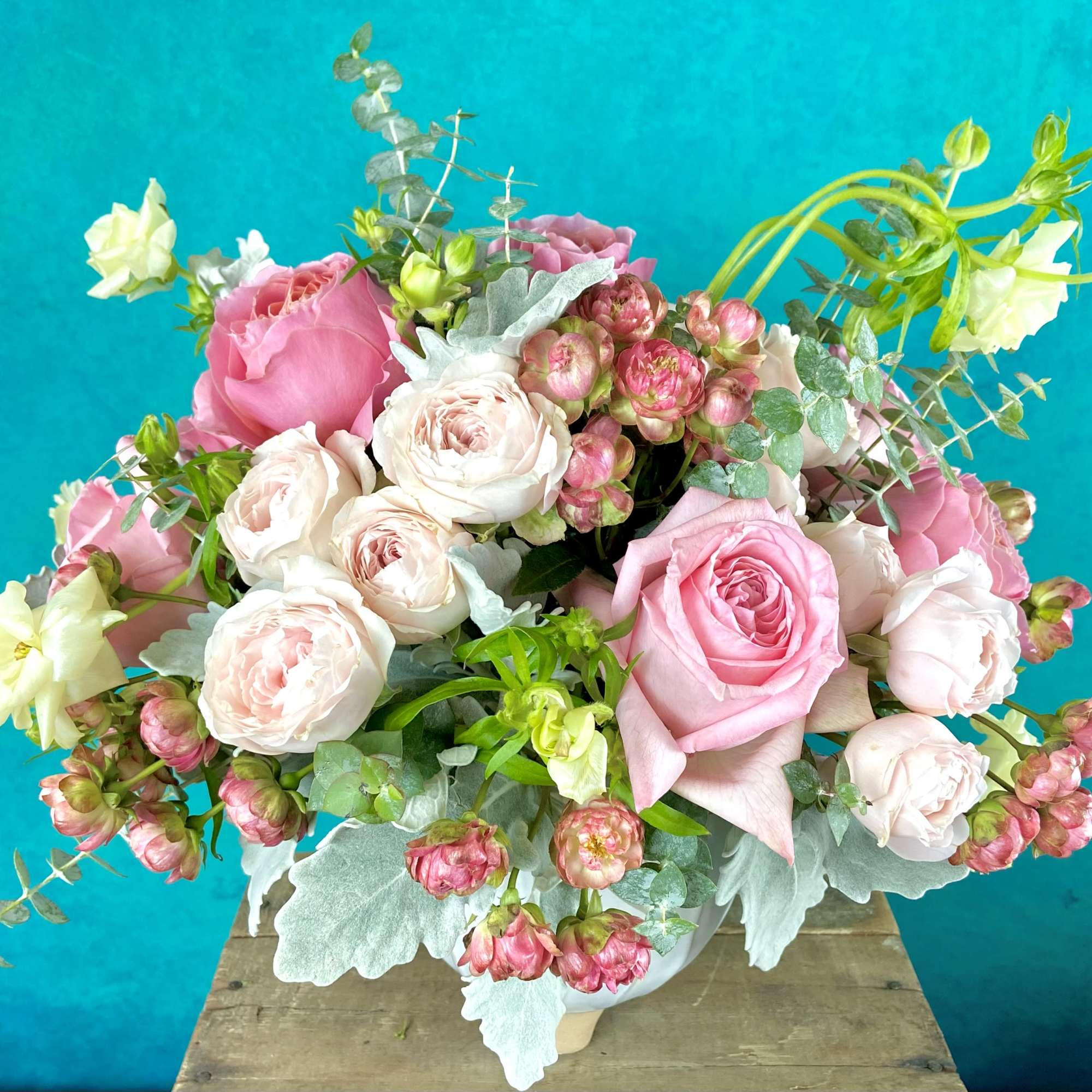 Low floral arrangement in seasonal colors, flowers and greenery.  Will likely