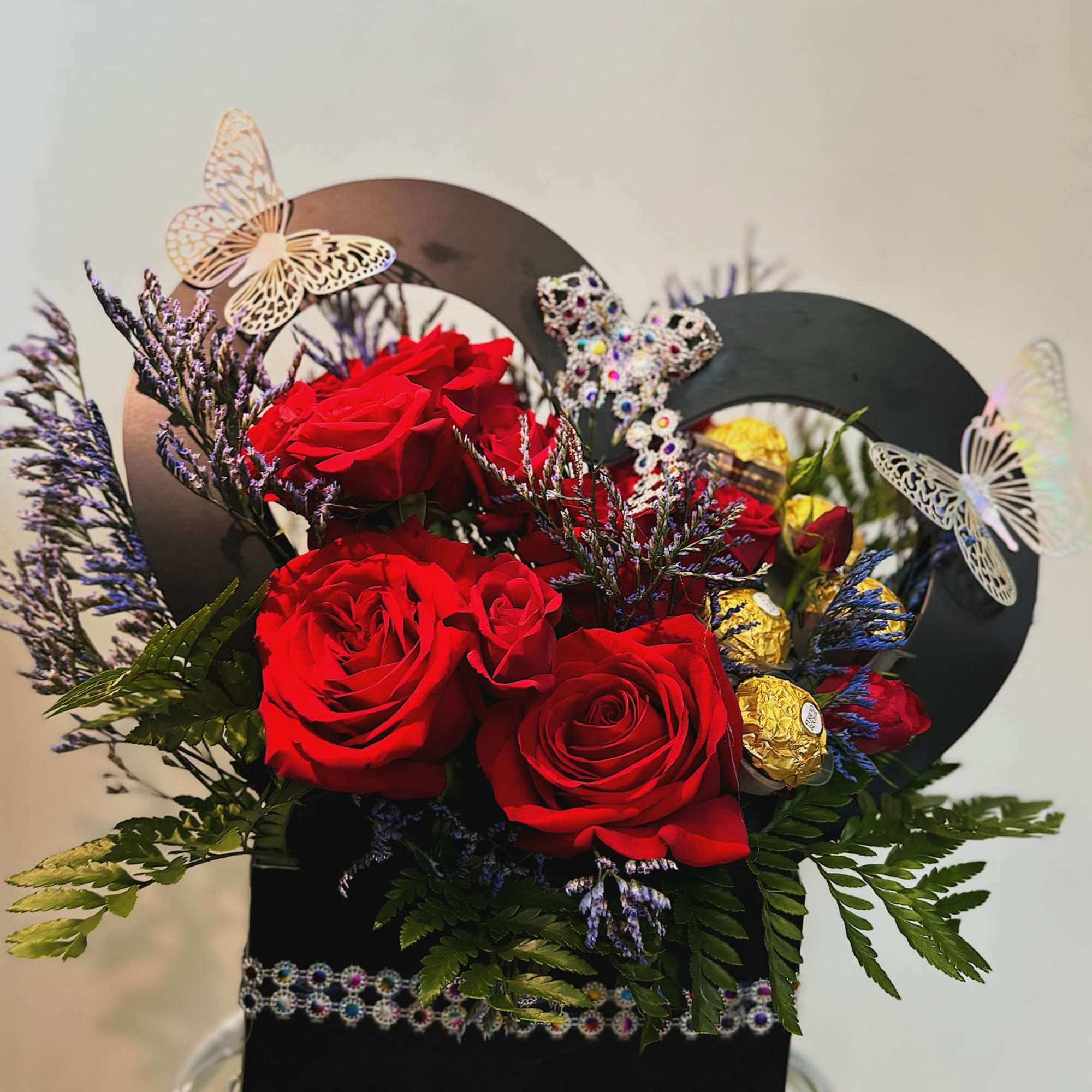 This arrangement is made with roses and chocolates. It is a small
