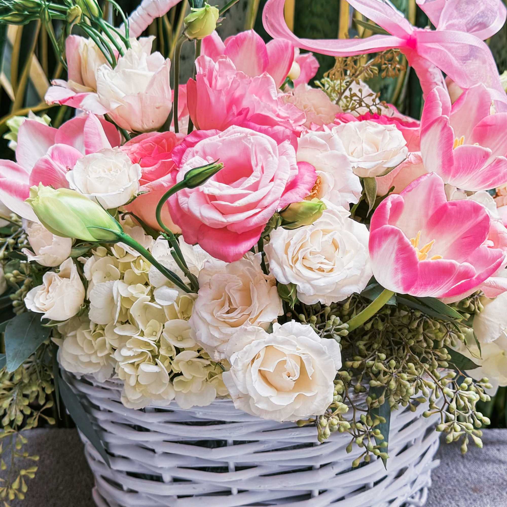 This charming basket bouquet brims with delicate pink roses, creamy white spray This charming basket bouquet brims with delicate pink roses, creamy white spray