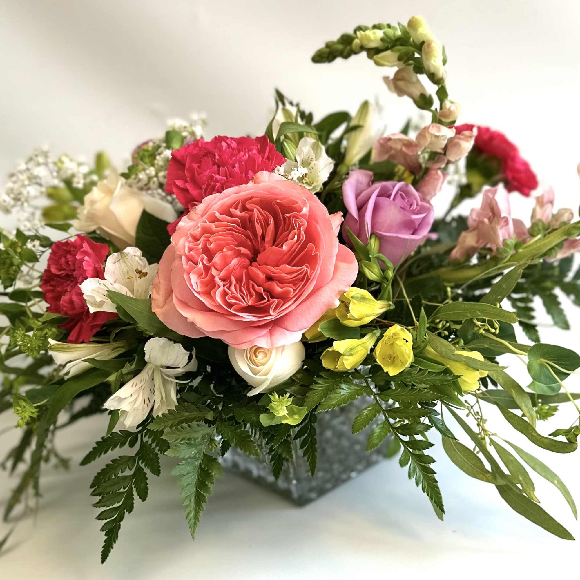 Contemporary bouquet made with a nice selection of flowers. Fun square vase Contemporary bouquet made with a nice selection of flowers. Fun square vase