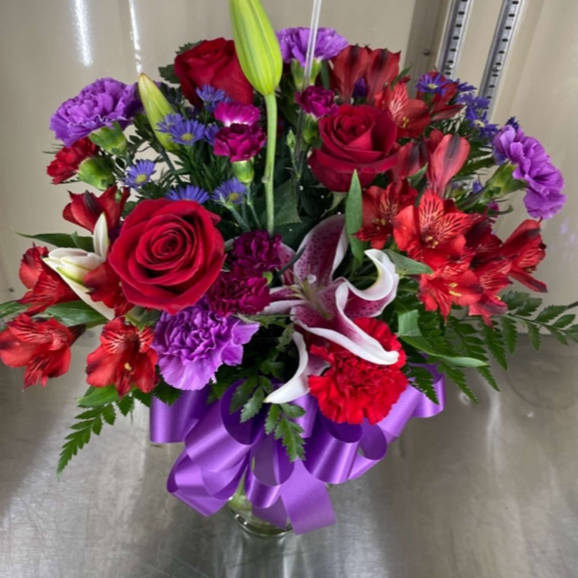 Mixed cut with red roses, red alstroemeria, purple carnations, and stargazer lilies