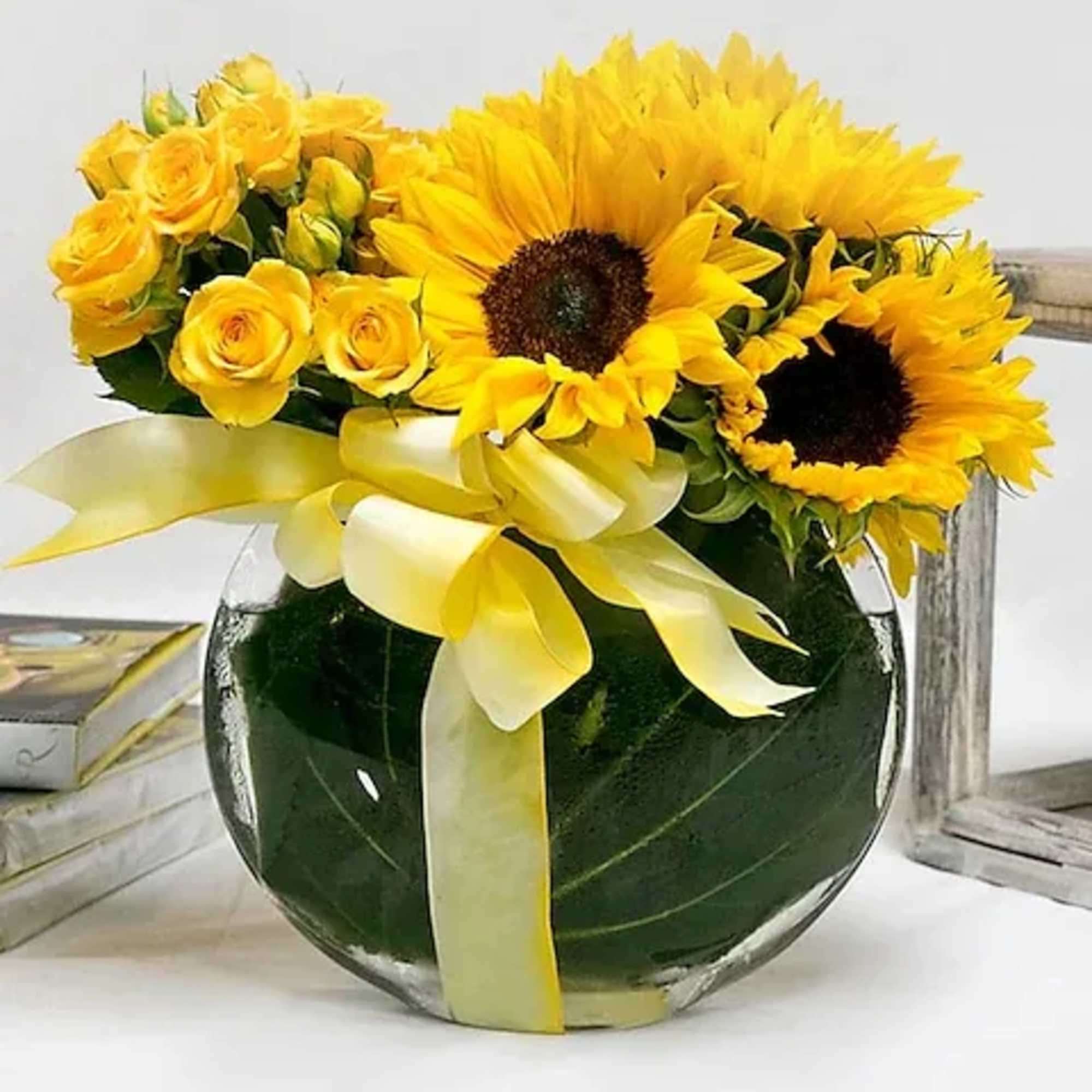 This mix of yellow spray roses and sunflowers is arranged in a