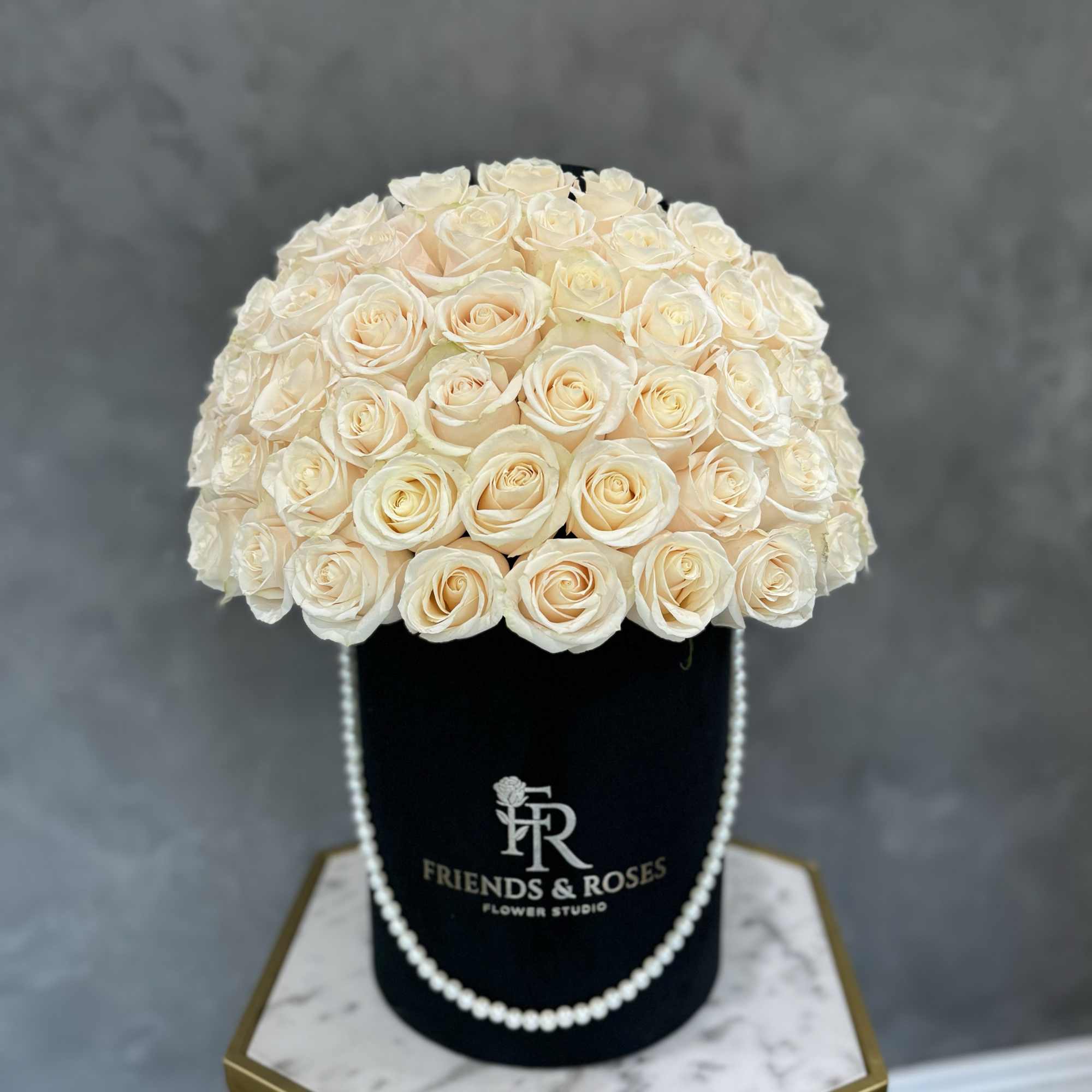 A gorgeous arrangement of white roses in our signature black box with