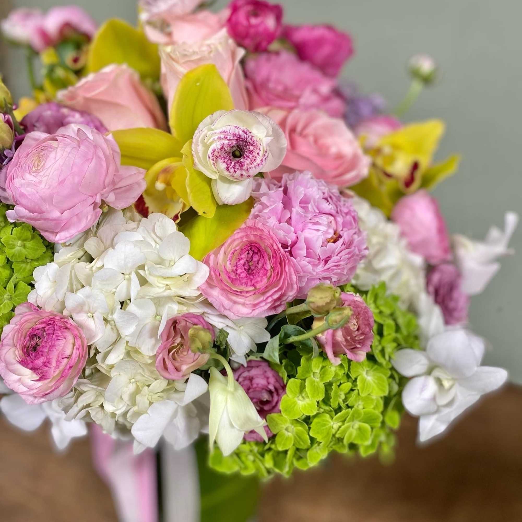 This exquisite arrangement includes hydrangeas, ranunculus, lisianthus, cymbidium orchids, roses and peonies.