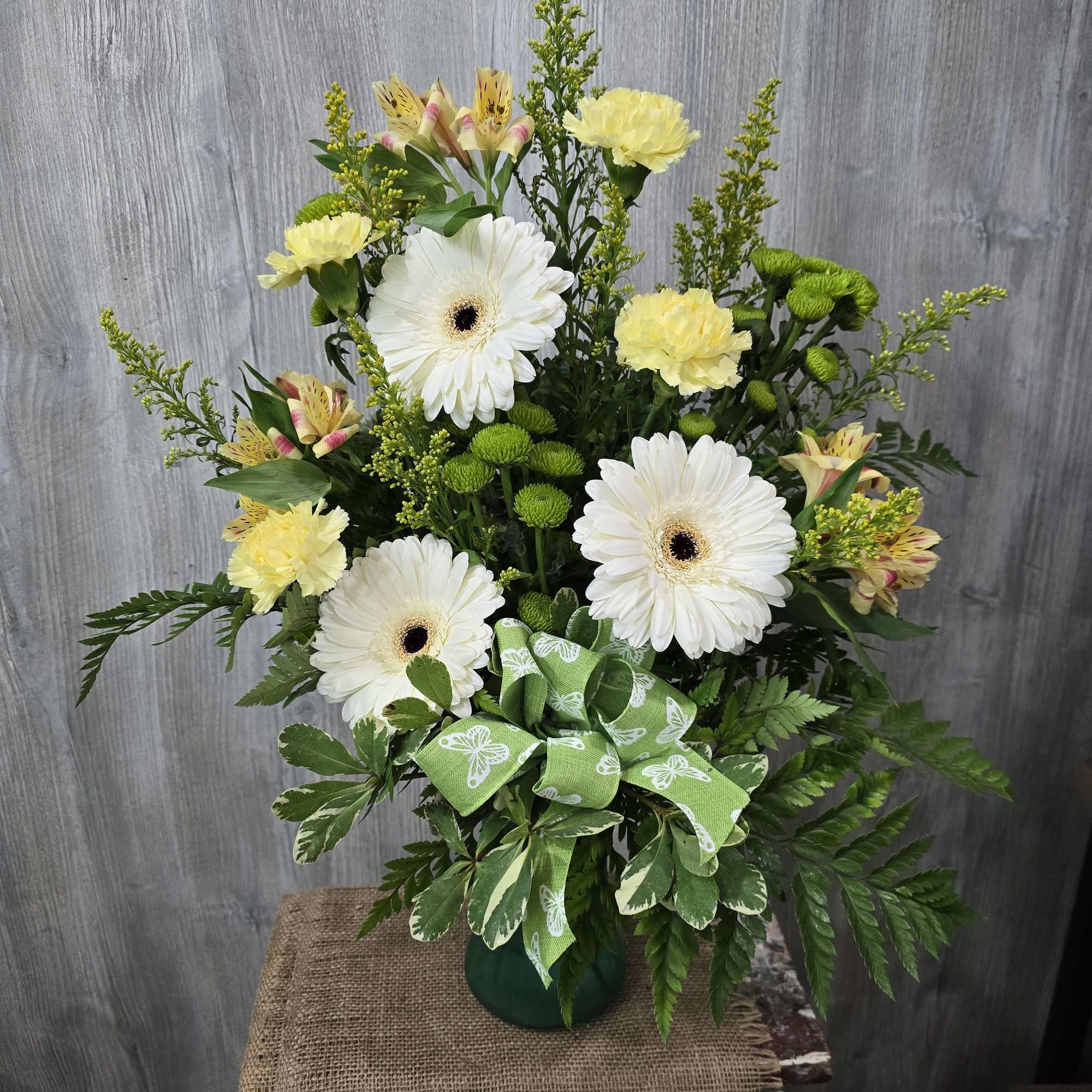 A beautiful vase full of neutral and green tones. Arranged with white