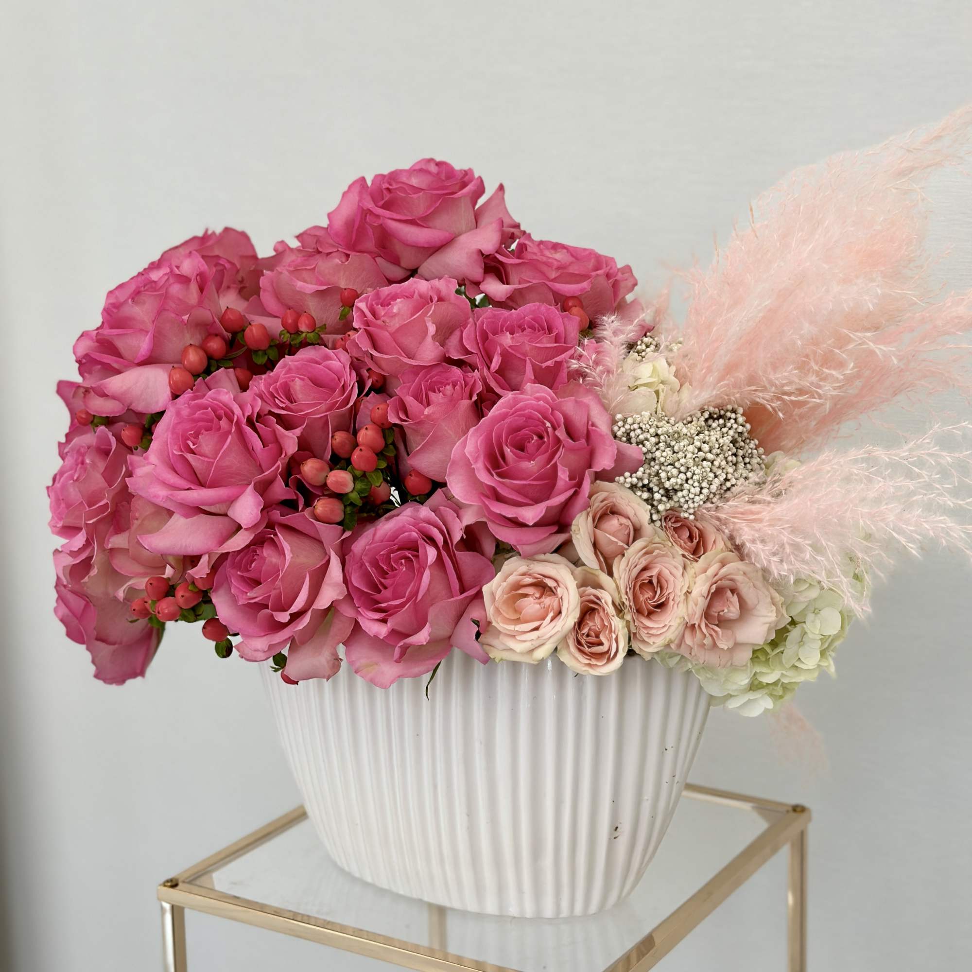 Nestled in a beautiful vase, this enchanting arrangement of pink roses evokes