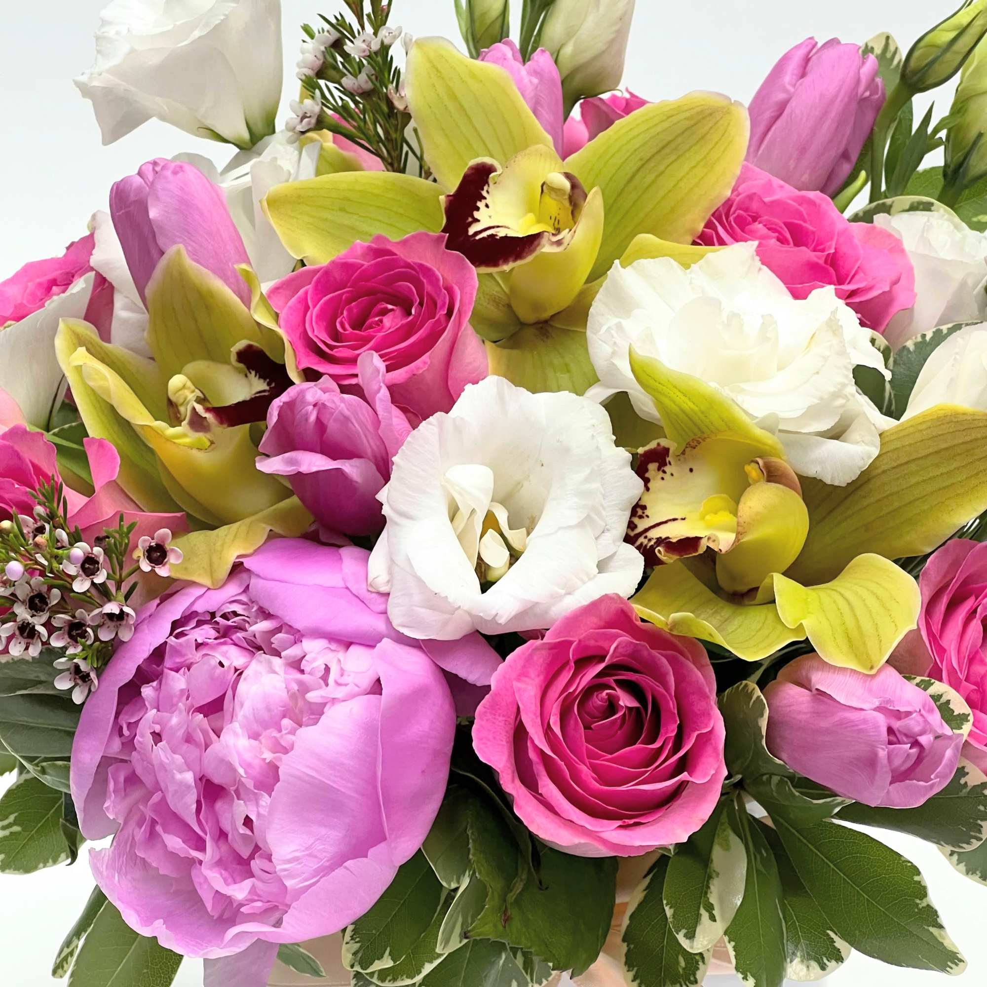 Melody is a floral composition made of roses, green orchids, and pink