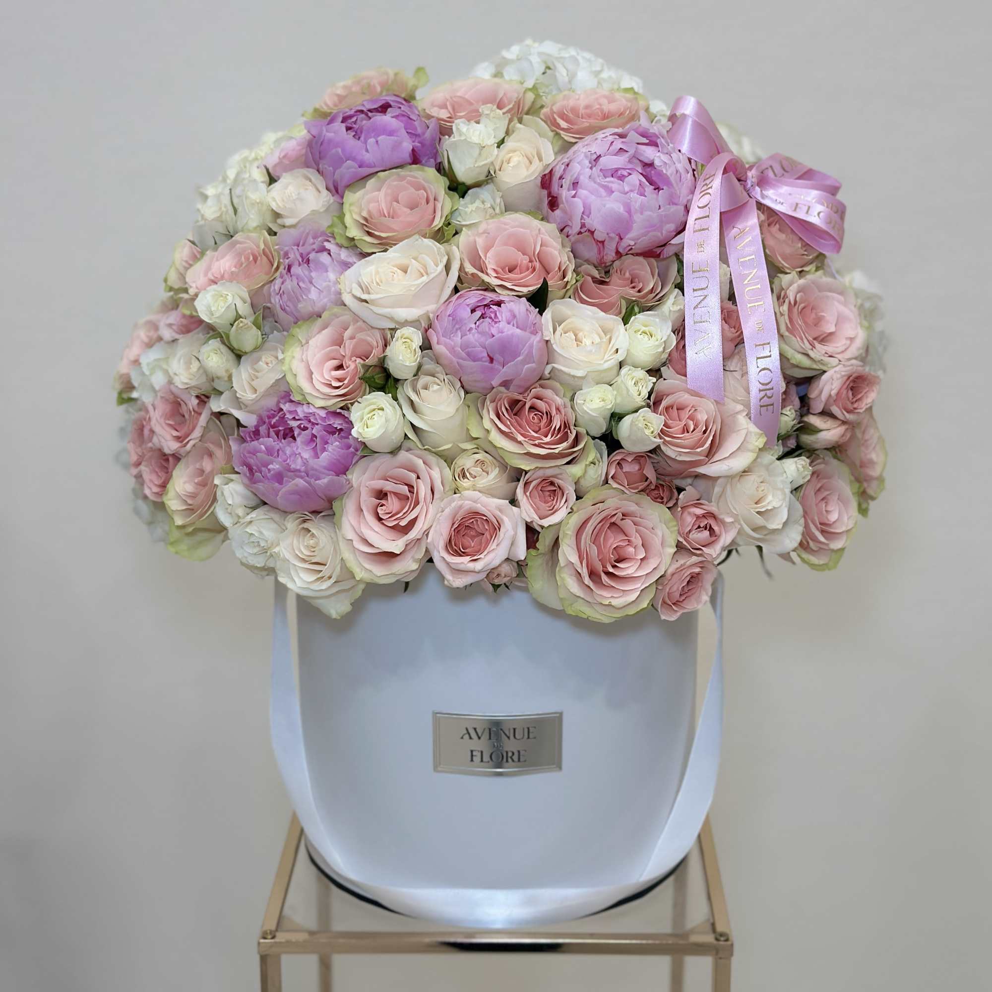 This delicate boxed arrangement features a soft blend of light pink and