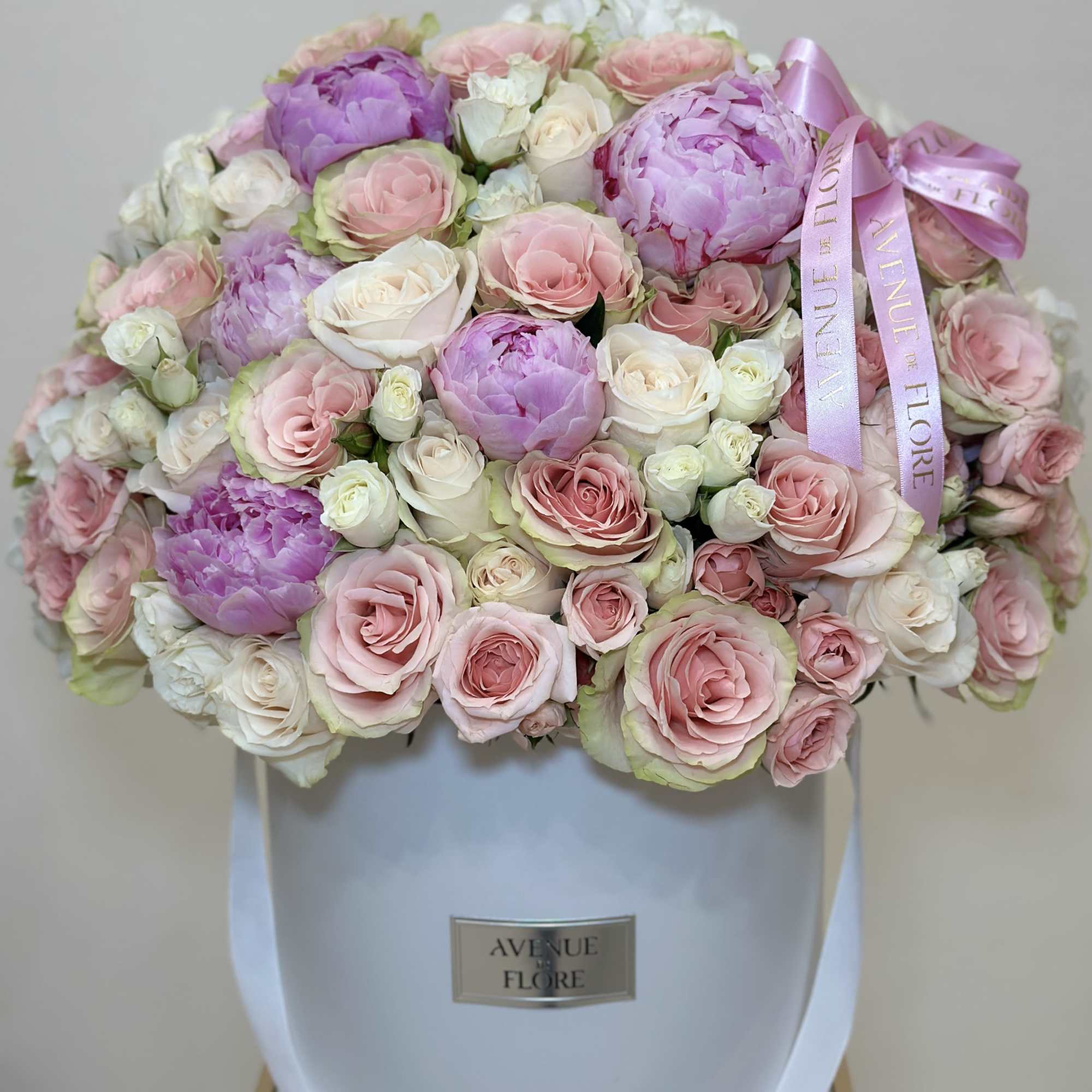 This delicate boxed arrangement features a soft blend of light pink and