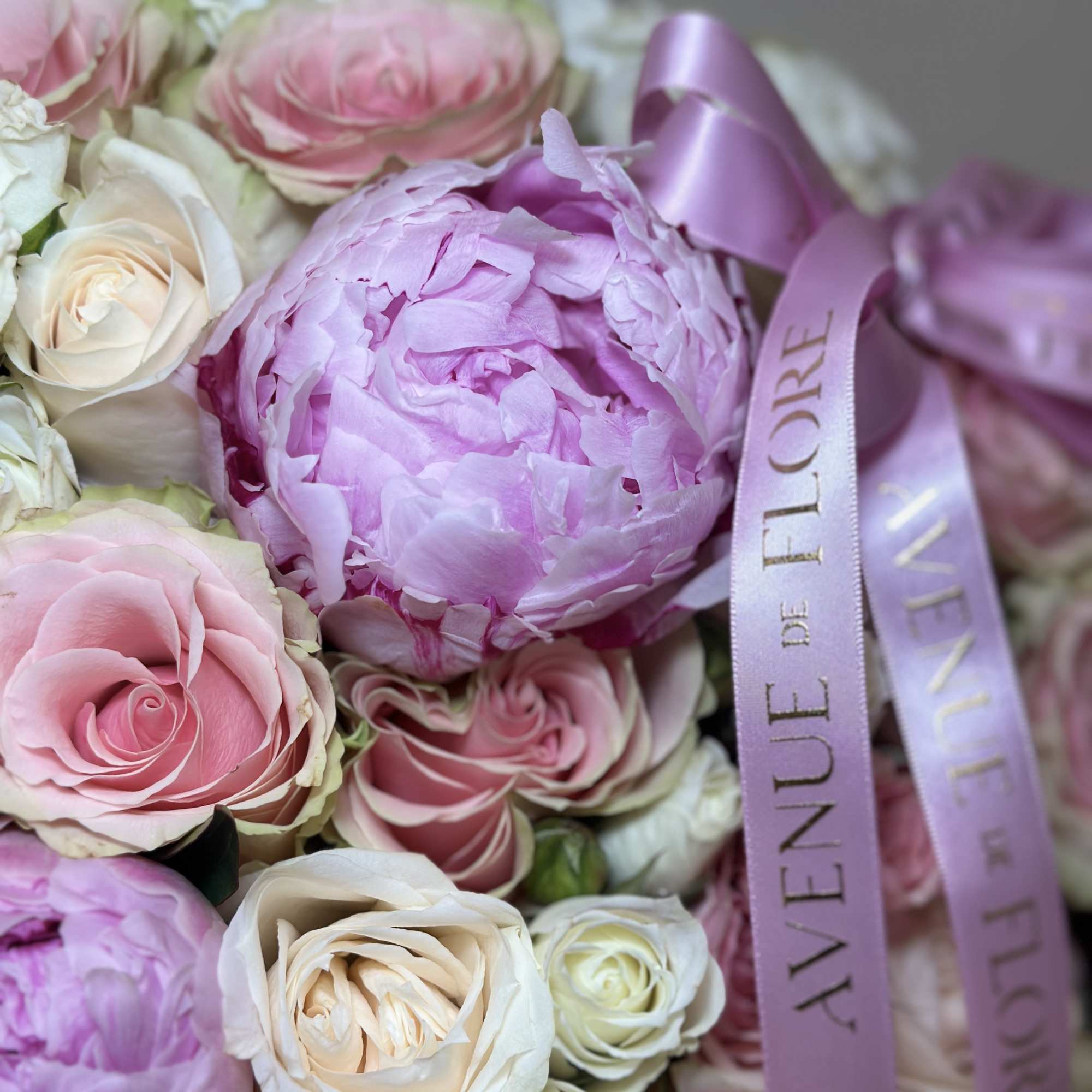 This delicate boxed arrangement features a soft blend of light pink and