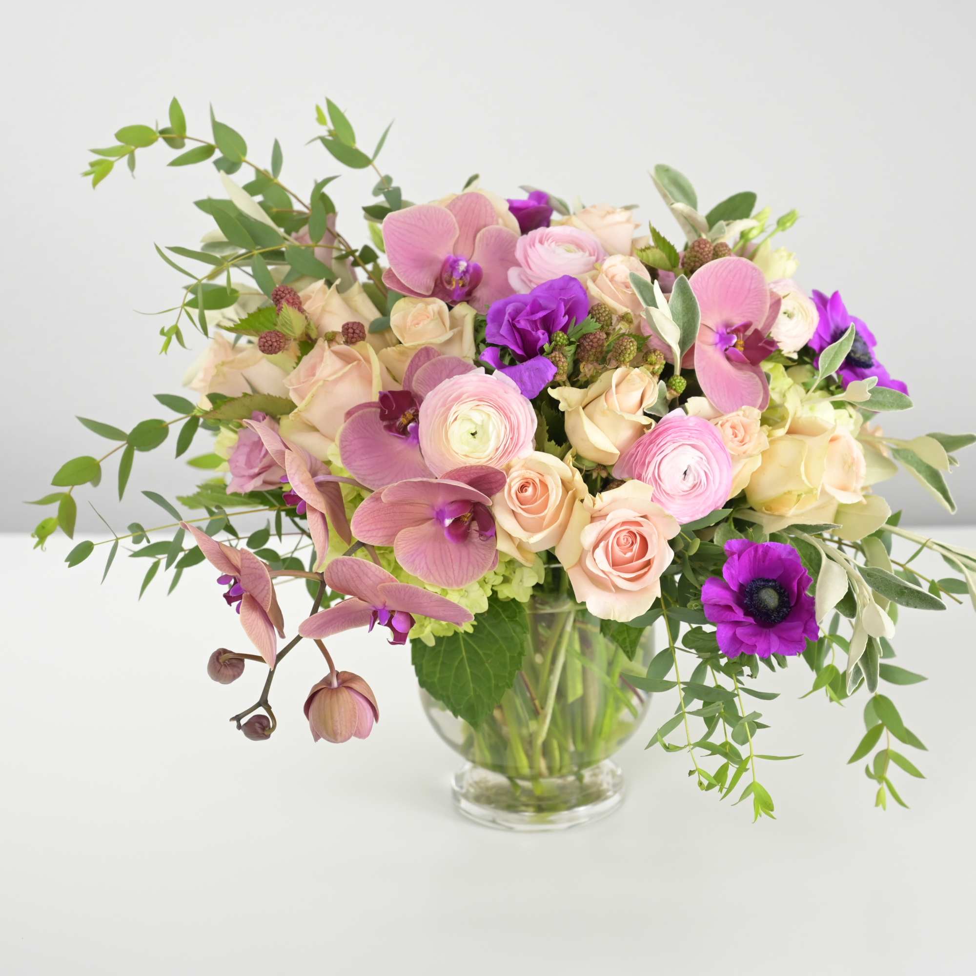 Romantic floral design witrh orchids anemones, ranunci=ulus and other seasonal flowers and
