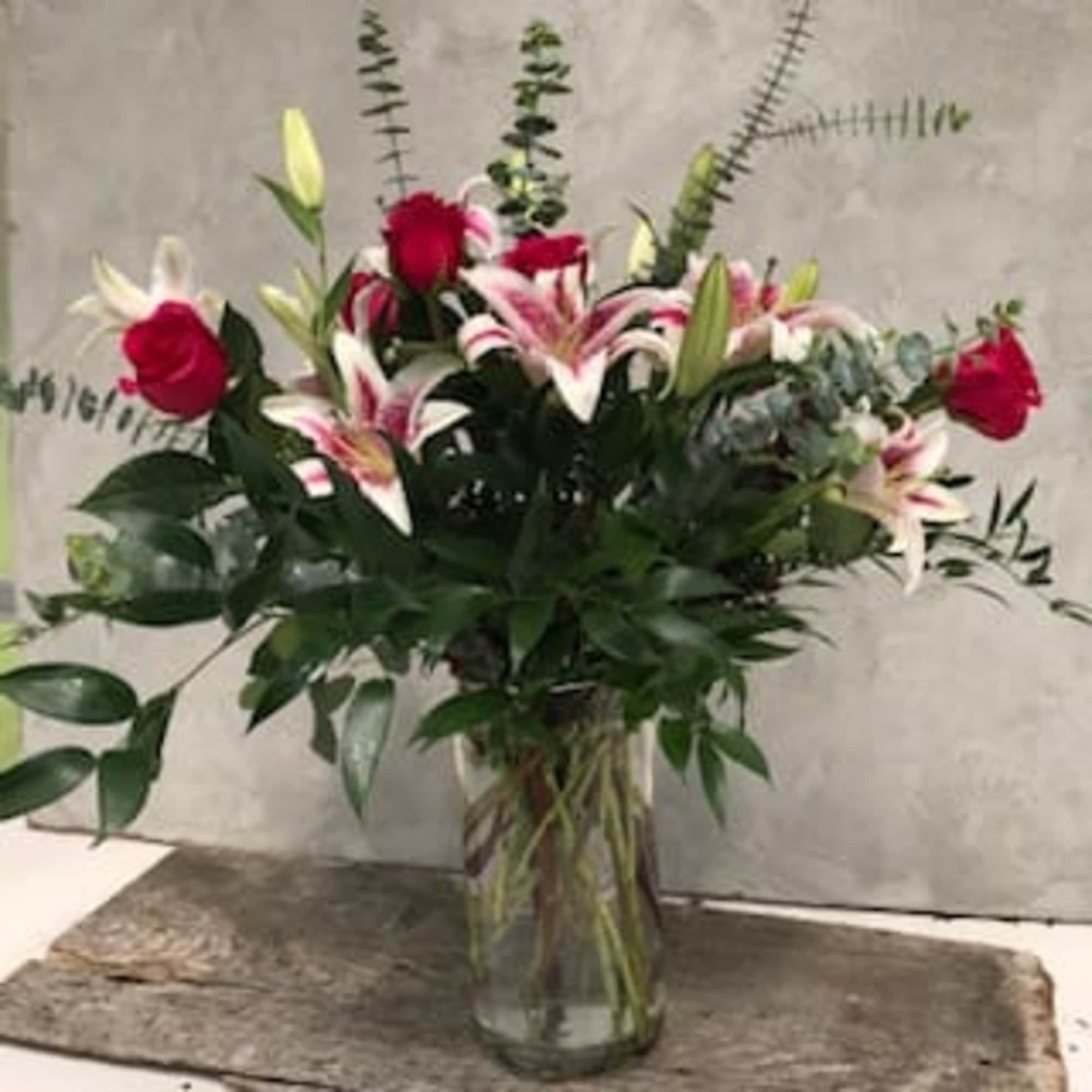 About 27 inches tall. This arrangement includes star gazer lilies, hot pink