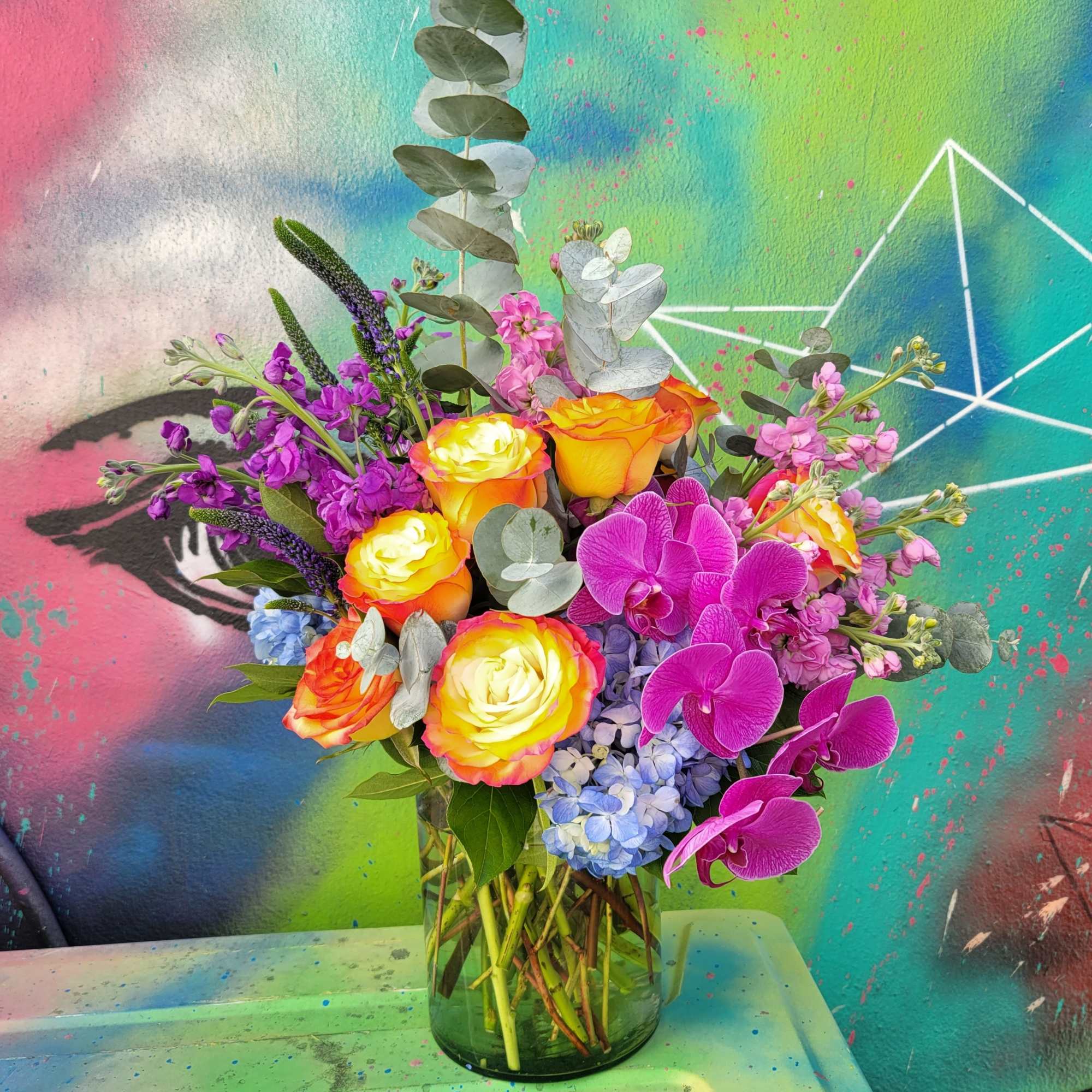 An arrangement made in a tall glass cylinder with Roses, hydrangeas, orchids An arrangement made in a tall glass cylinder with Roses, hydrangeas, orchids