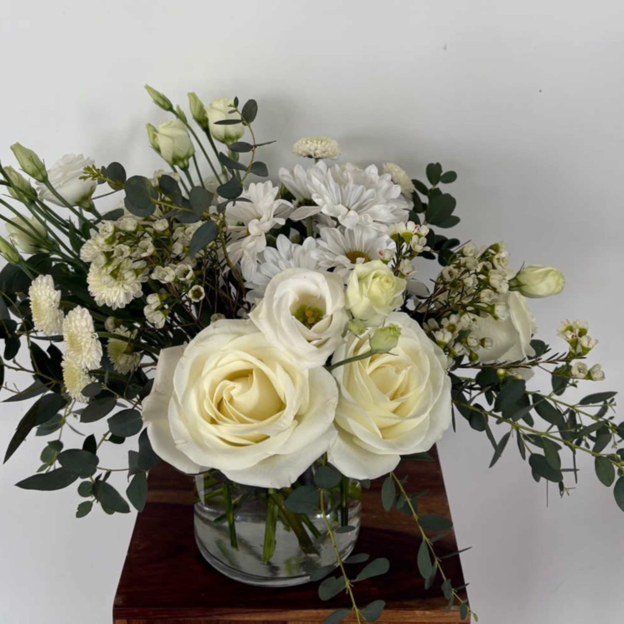 A mix of designer&rsquo;s choice white blooms of Lisianthus, Mum, Rose, Alstroemeria