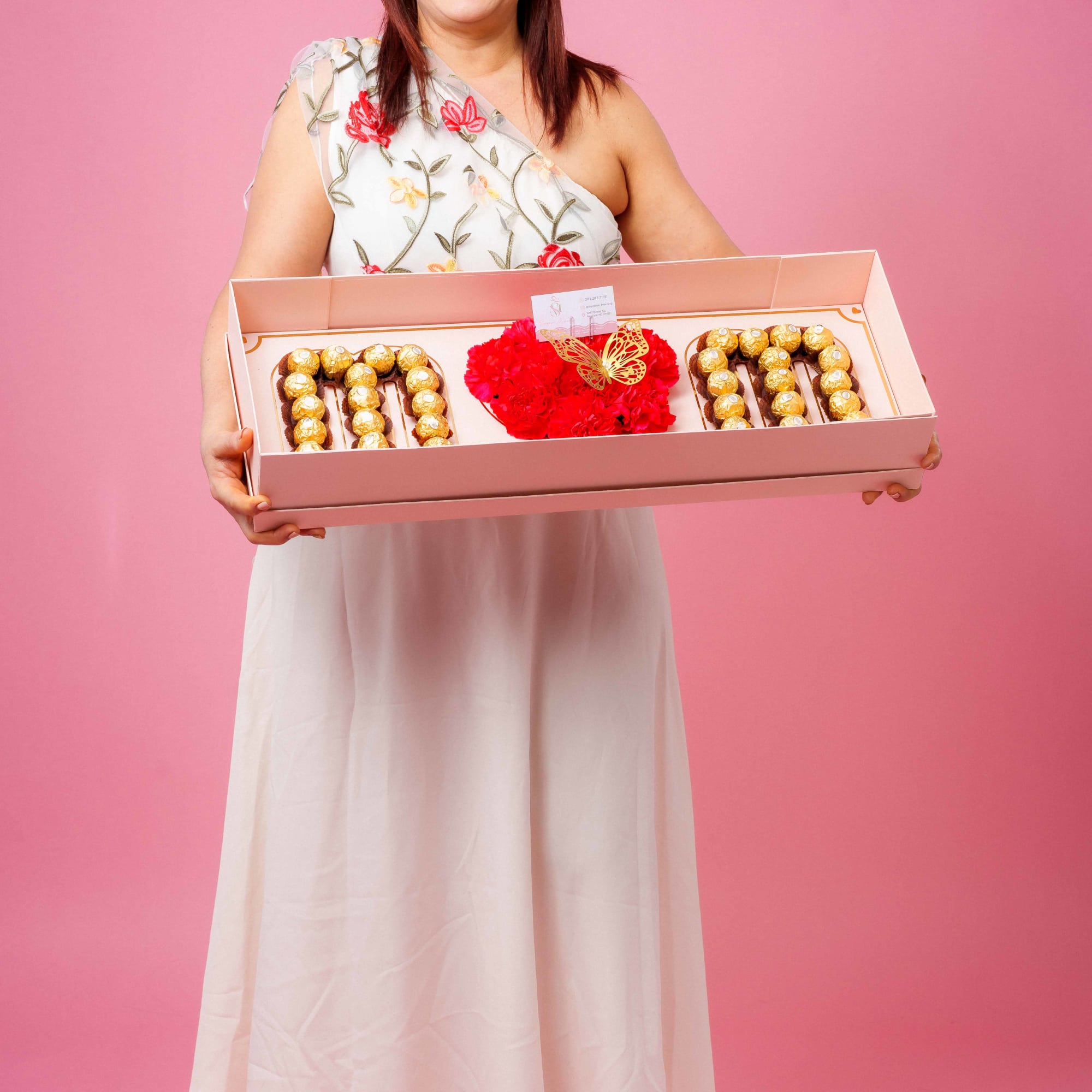 An elegant box with premium chocolates and fresh flowers that spell out