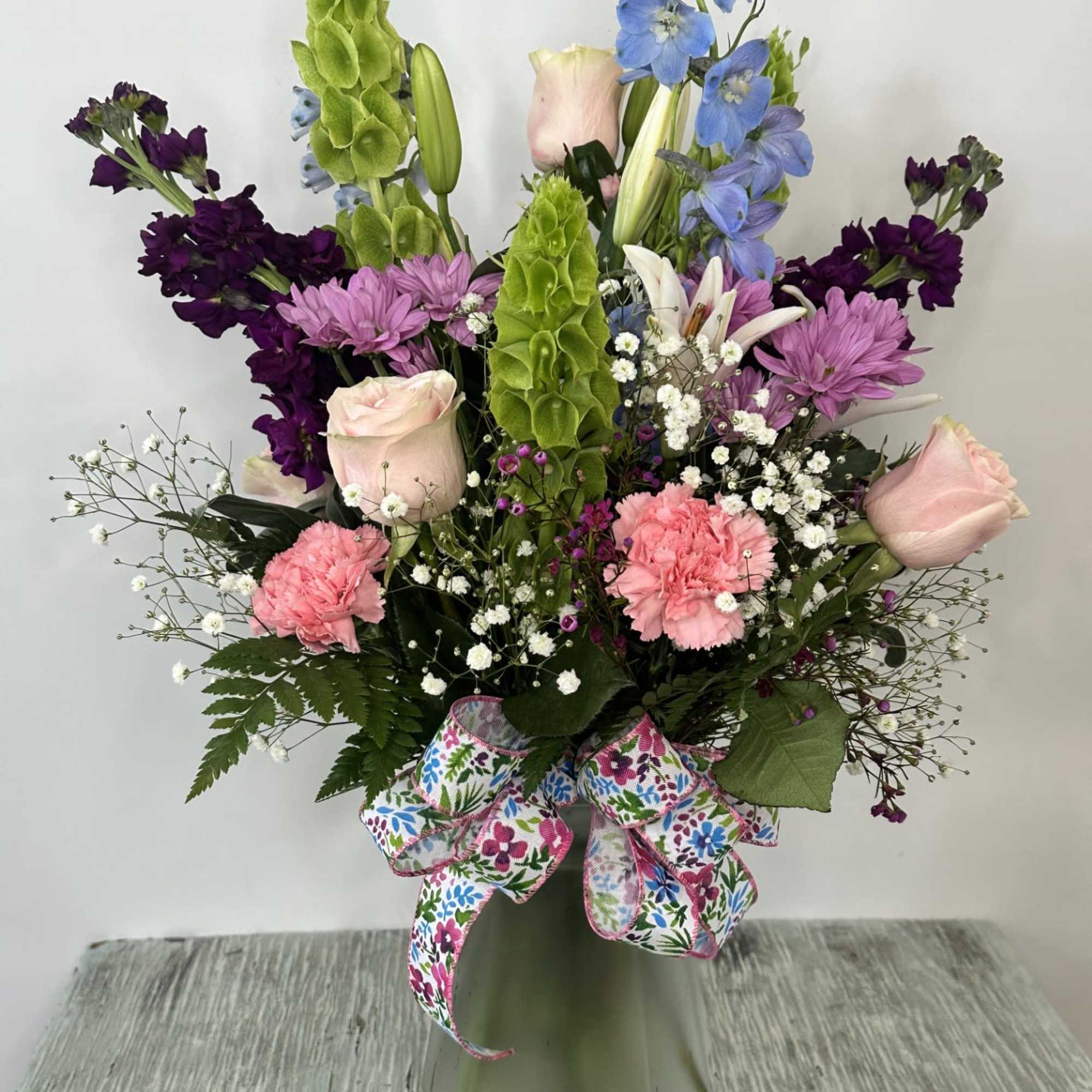 Arrangement of fresh cut flowers designed in a glass vase. Vase comes Arrangement of fresh cut flowers designed in a glass vase. Vase comes