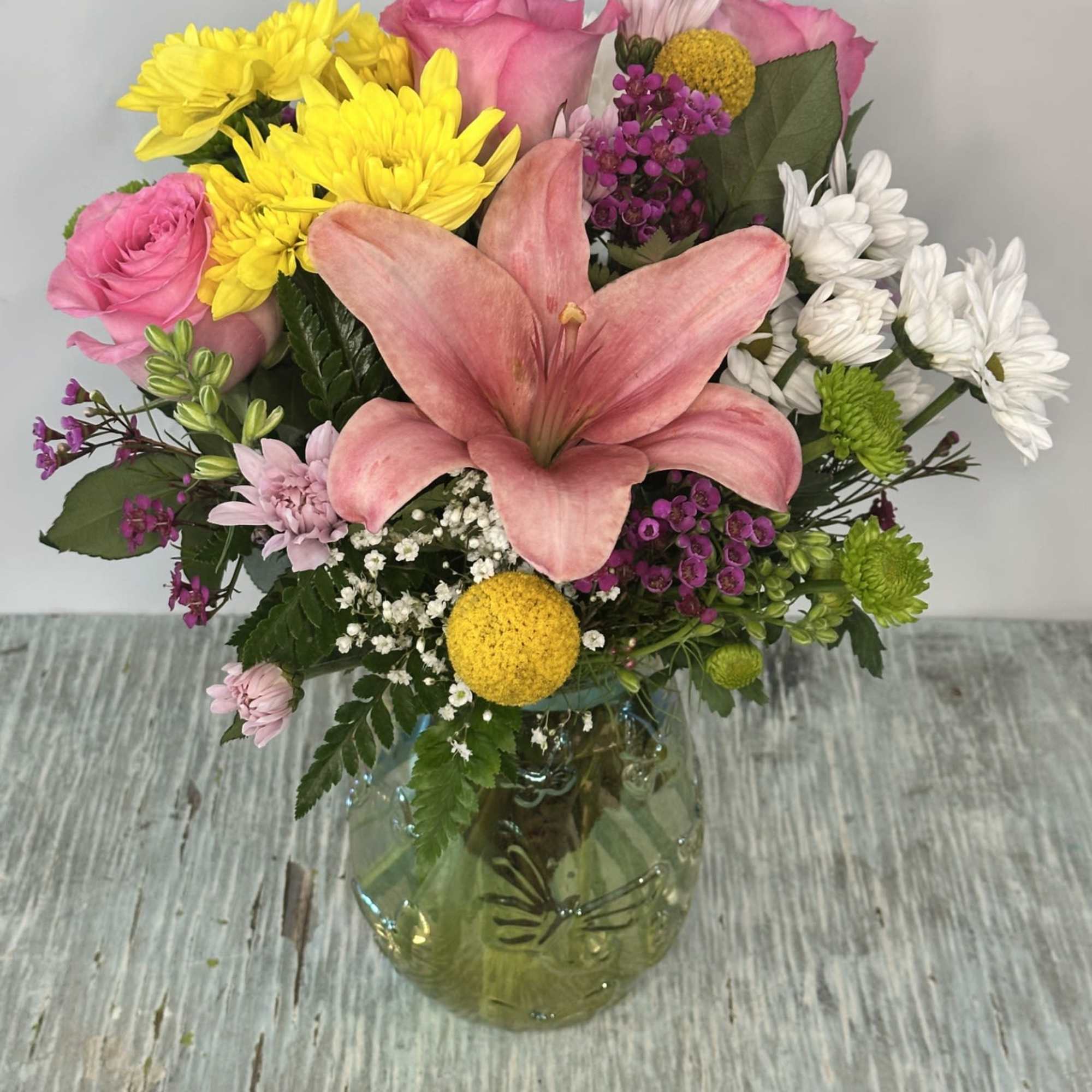 Arrangement of mixed flowers designed in a iridescent pastel colored vase. Vase Arrangement of mixed flowers designed in a iridescent pastel colored vase. Vase
