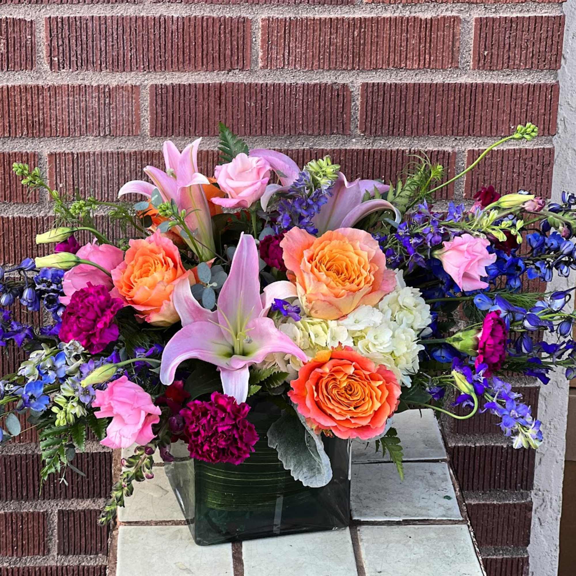 Filled with lush blooms in a garden style, this arrangement in a Filled with lush blooms in a garden style, this arrangement in a