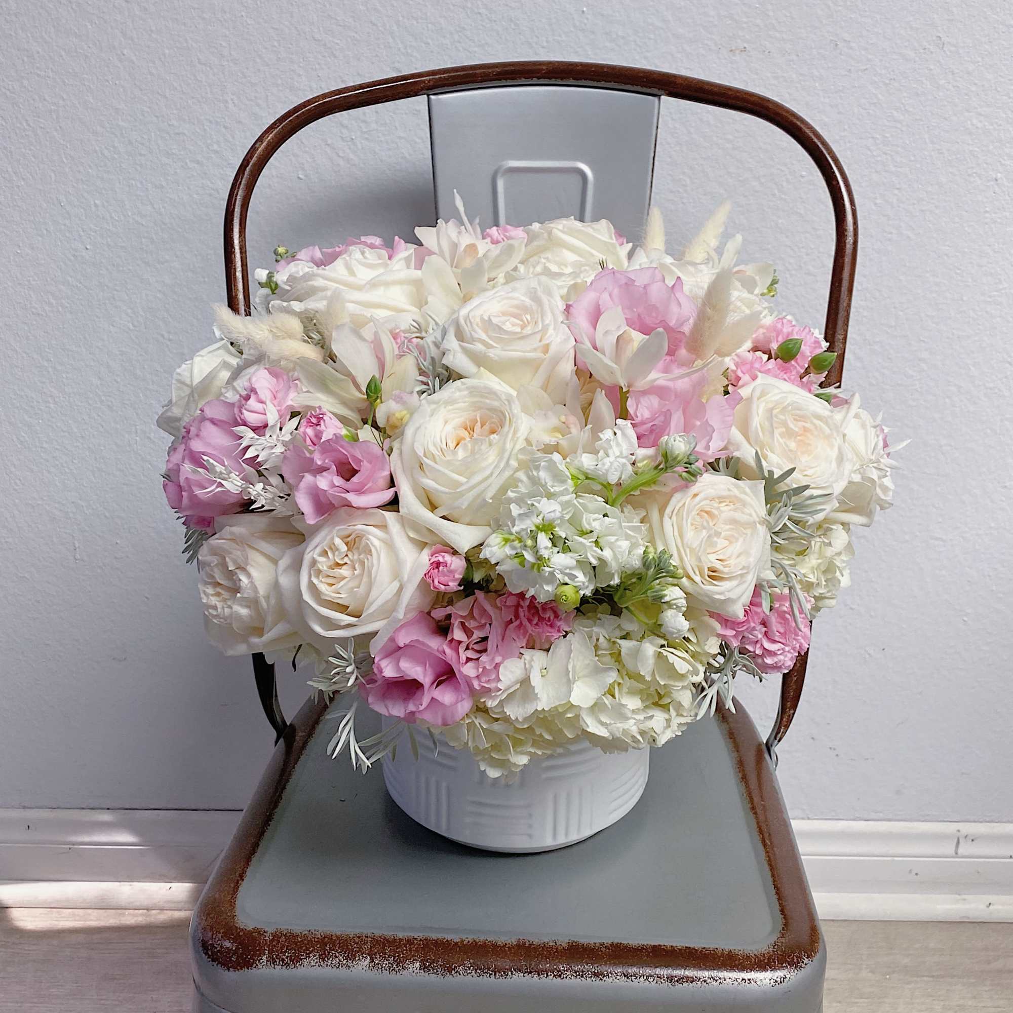 Arrangement with garden roses, orchids, hydrangeas, lisianthus, stock, dry grass, and other