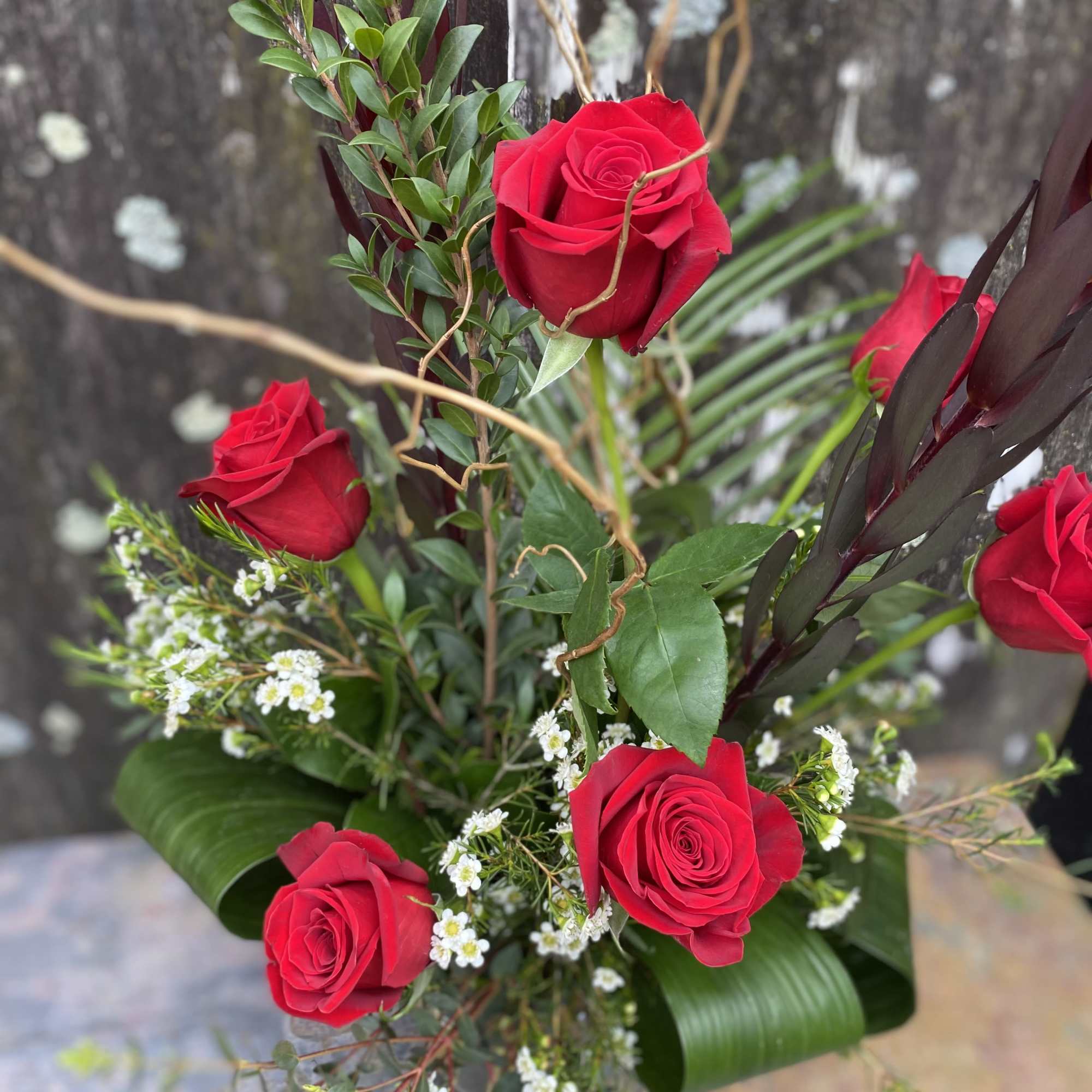 Six roses arranged in a tall glass vase.
To request another color than