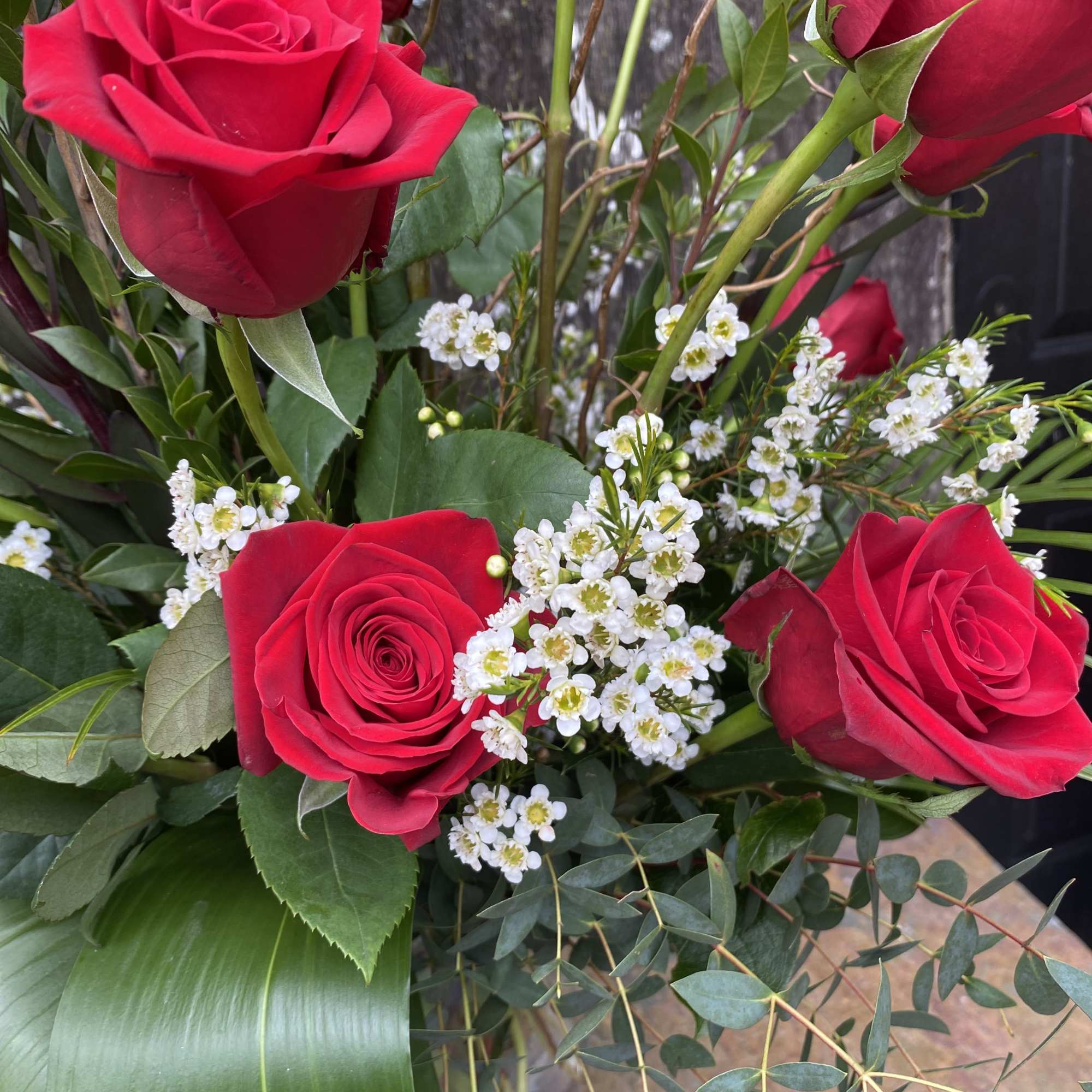 Twelve roses arranged in a tall glass vase. 
To request another color