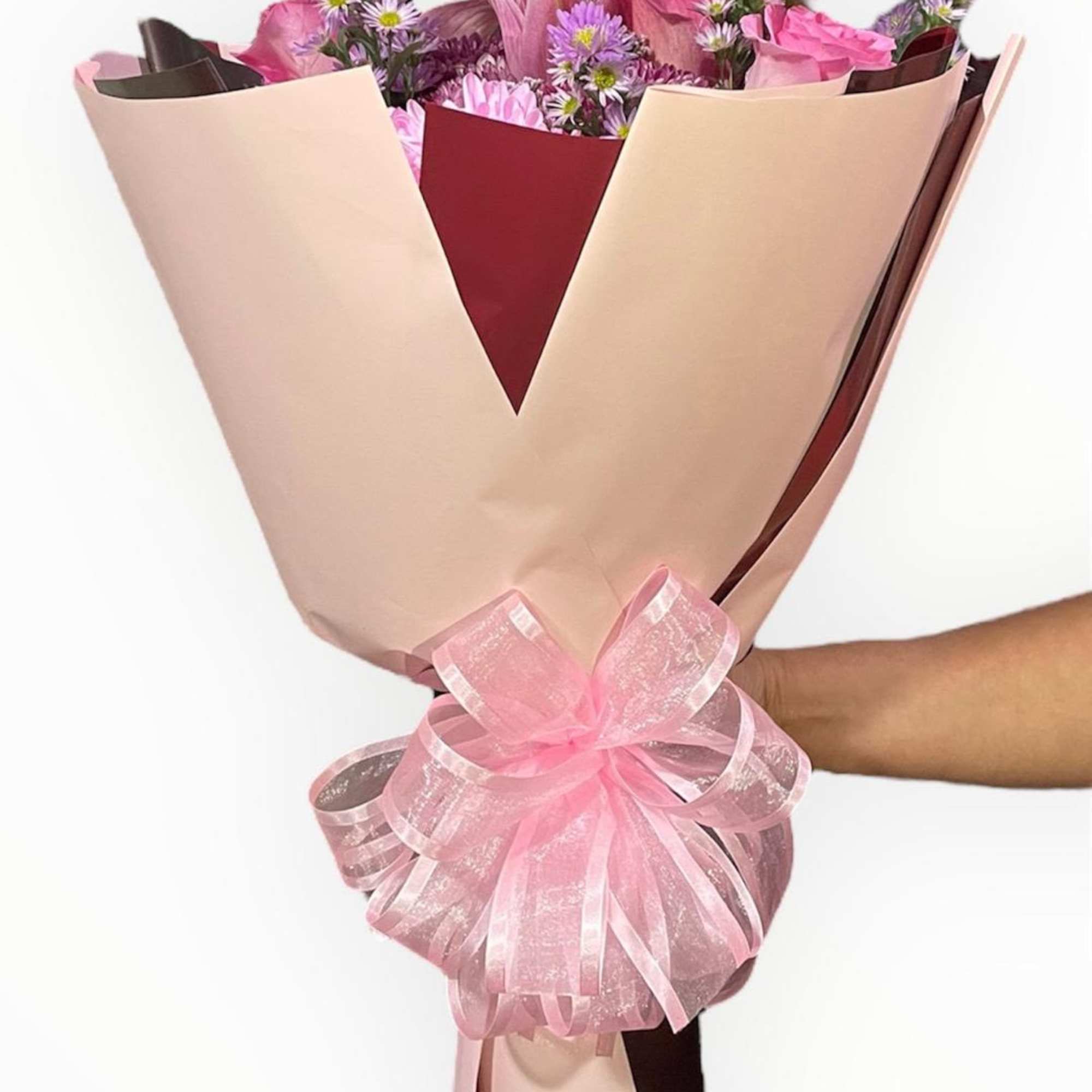 This stunning wrap bouquet has pink roses, cushions, rose lilies, deep pink