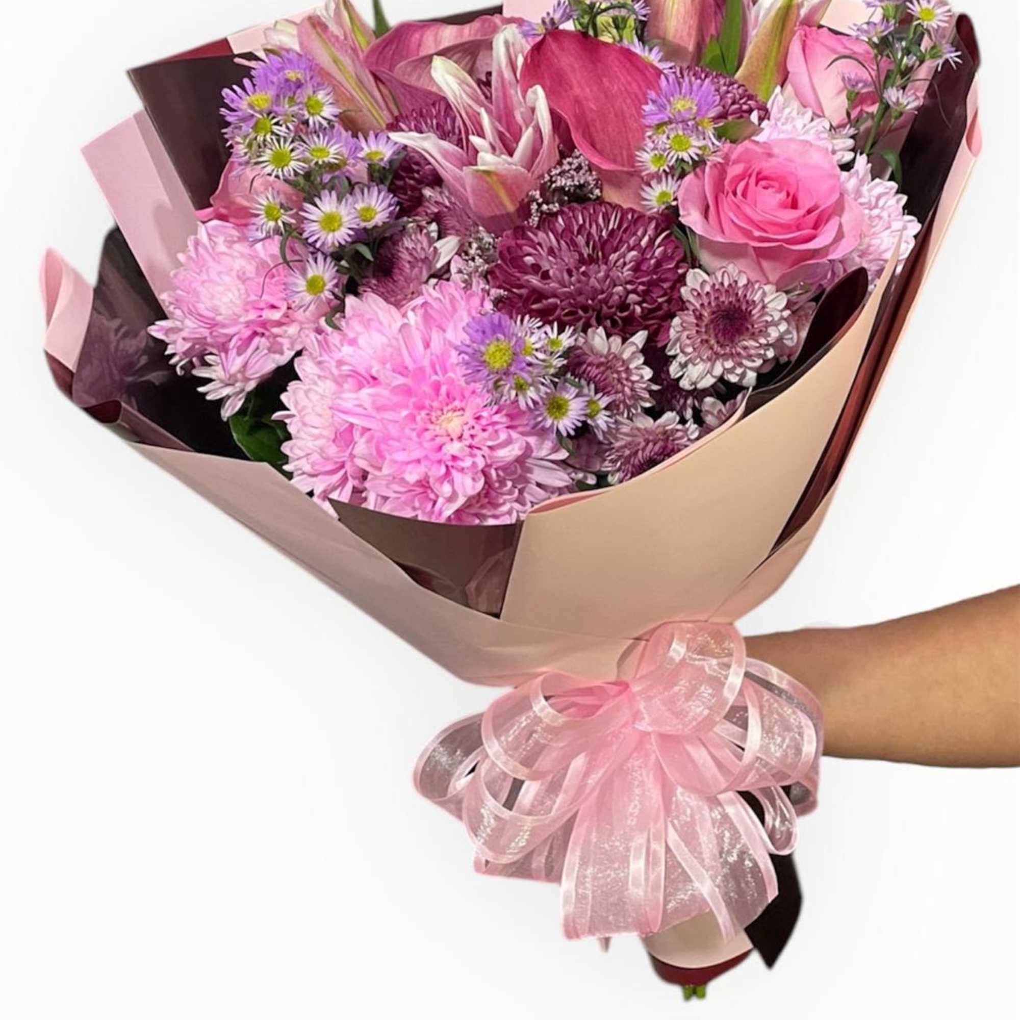 This stunning wrap bouquet has pink roses, cushions, rose lilies, deep pink