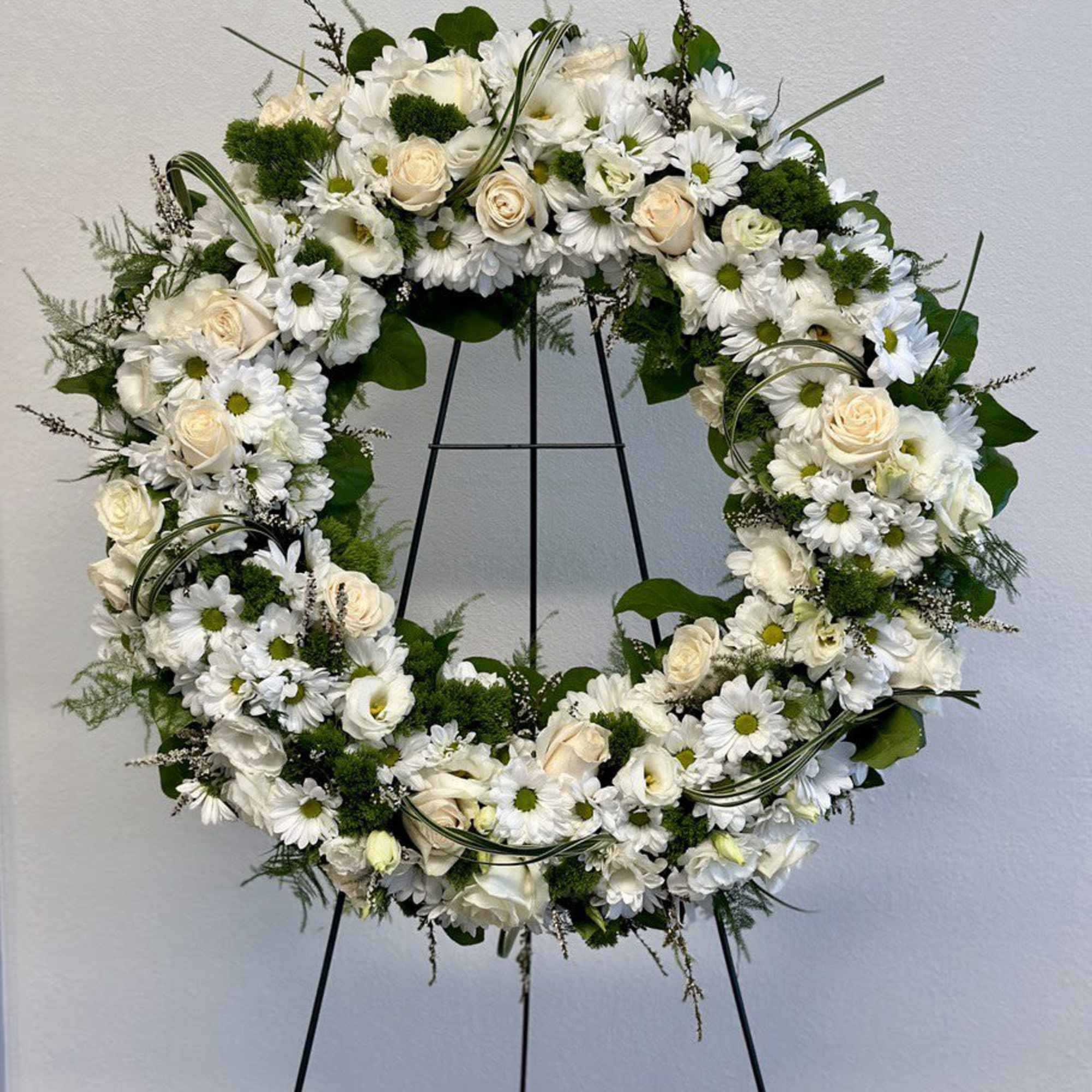 A beautiful white and green tribute wreath that calms, this easel arrangement