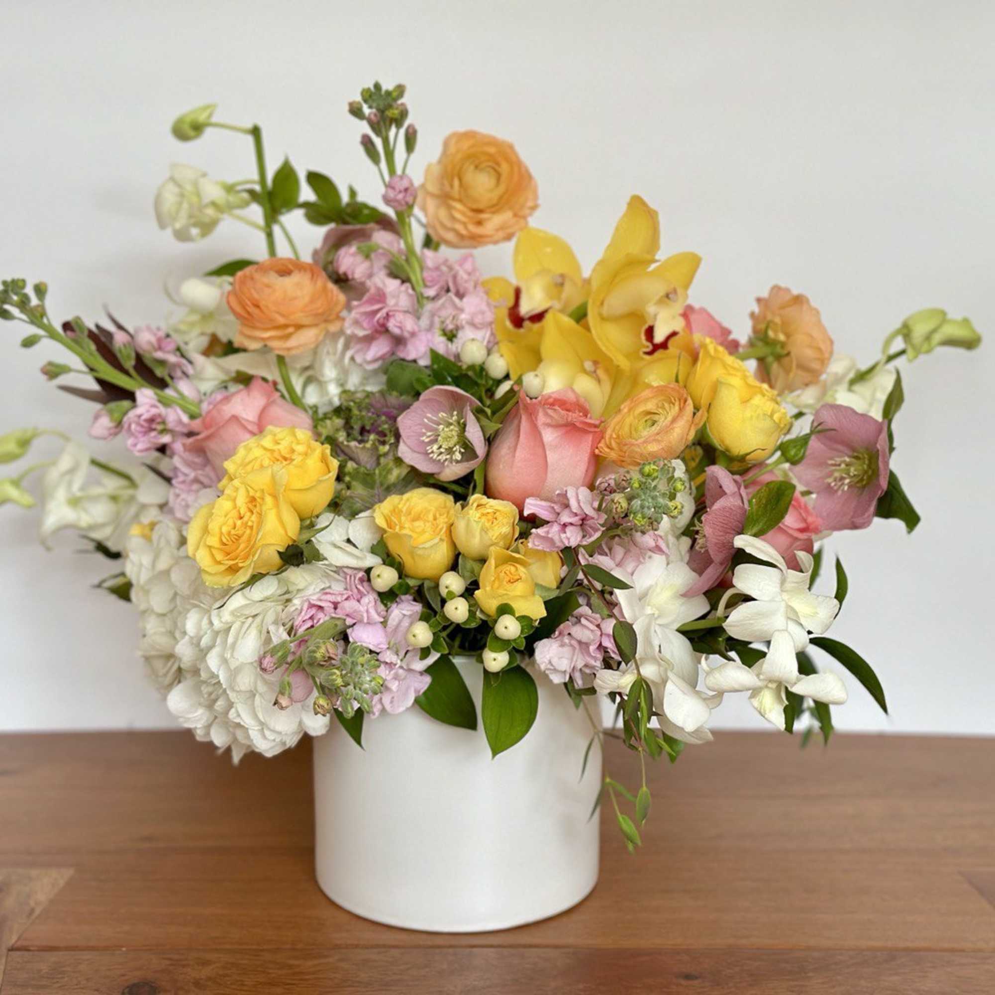 An elegant flower arrangement made in a white ceramic vase. This is
