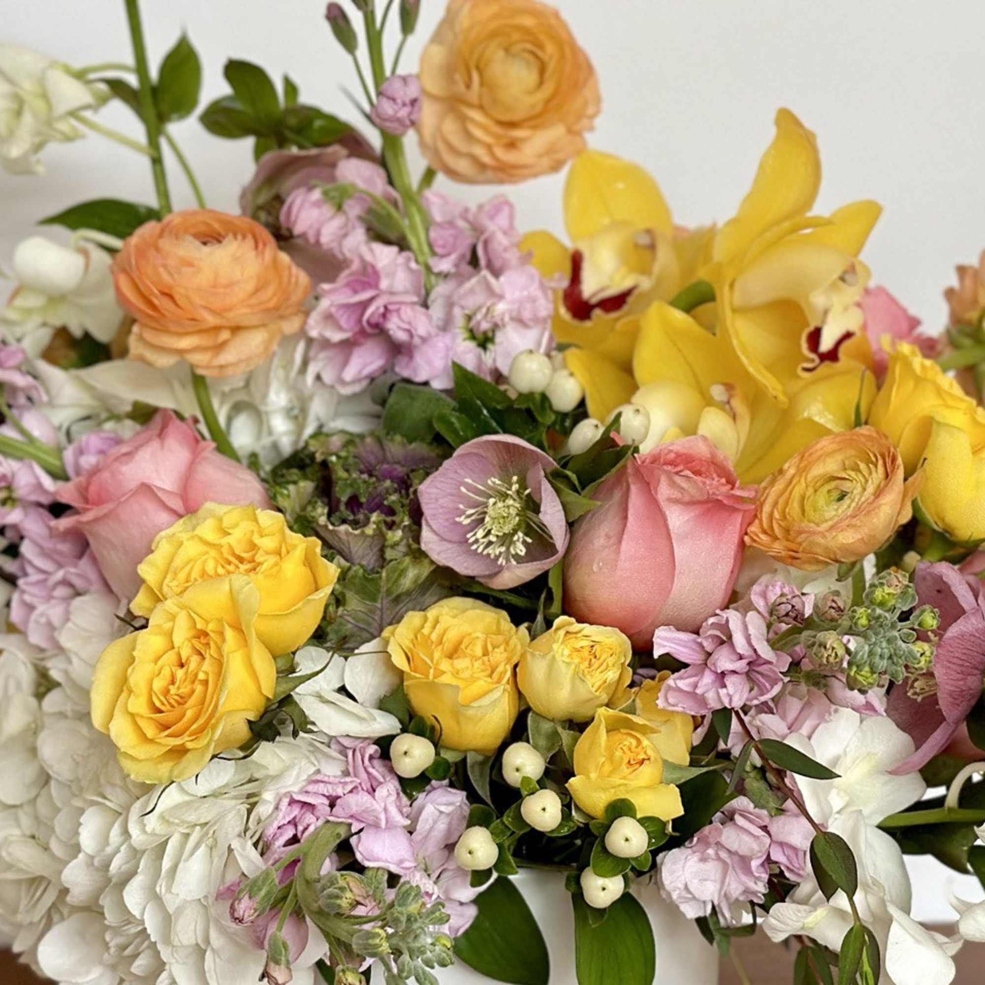 An elegant flower arrangement made in a white ceramic vase. This is