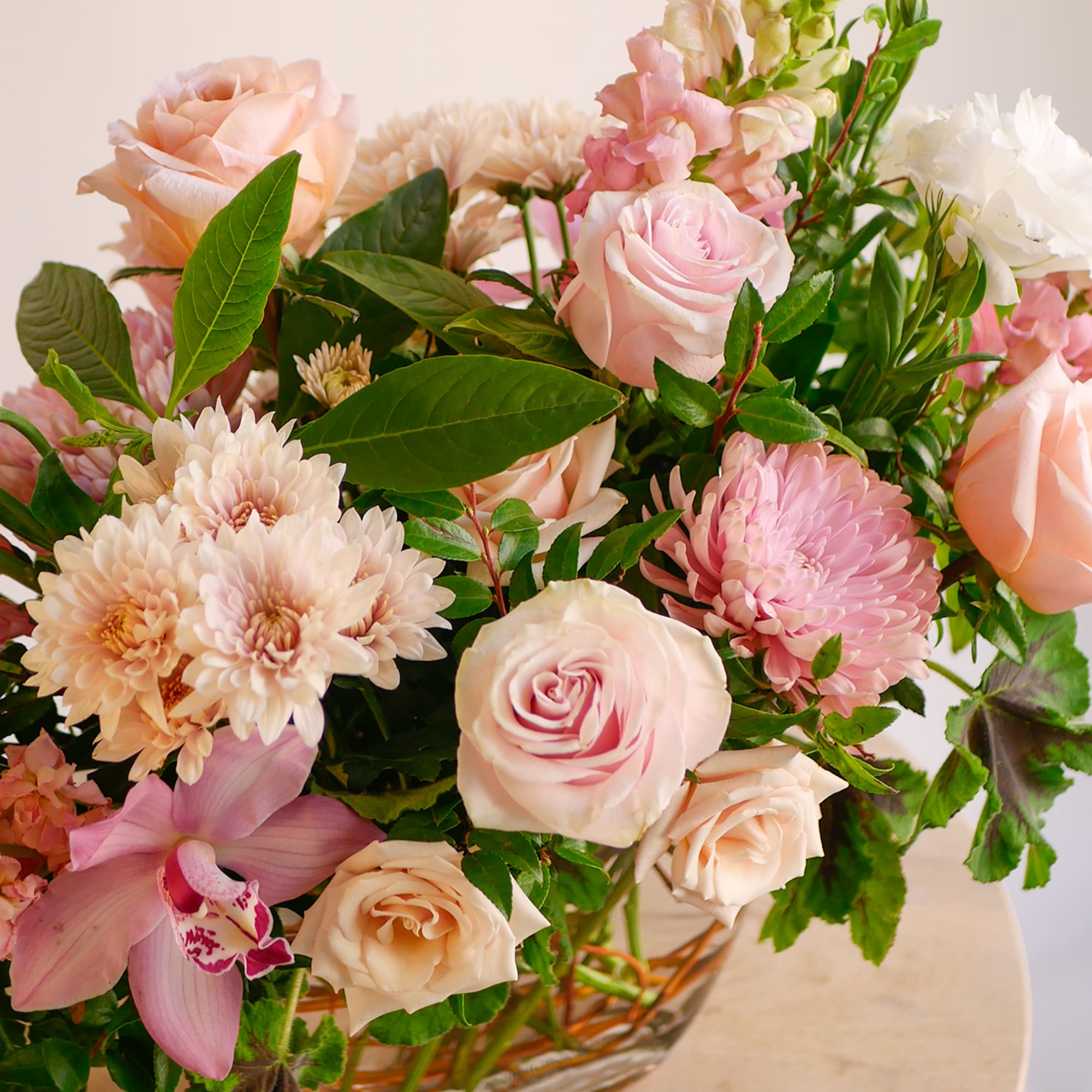This fun garden-style arrangement displays a premium collection of pale pink and