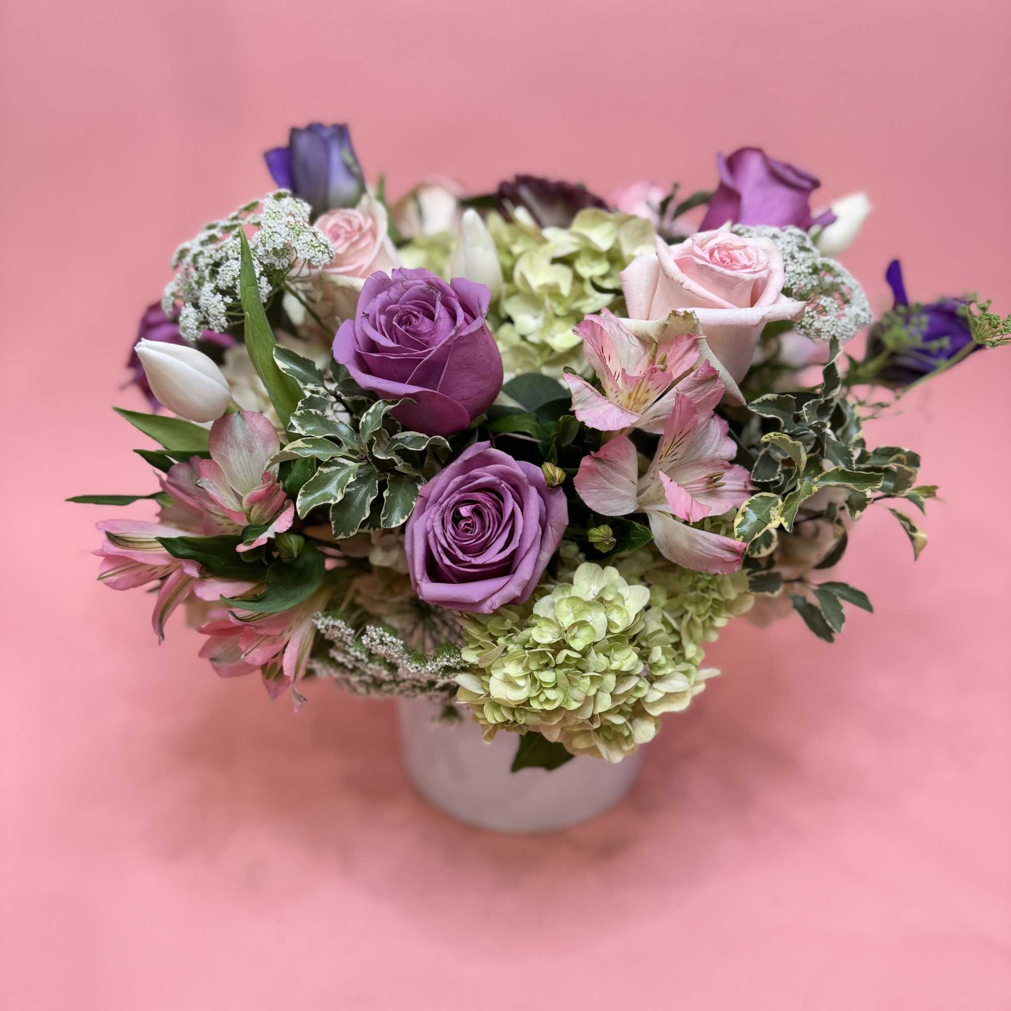 A happy mixture of hydrangeas, roses, lisianthus, and other seasonal pink &amp;