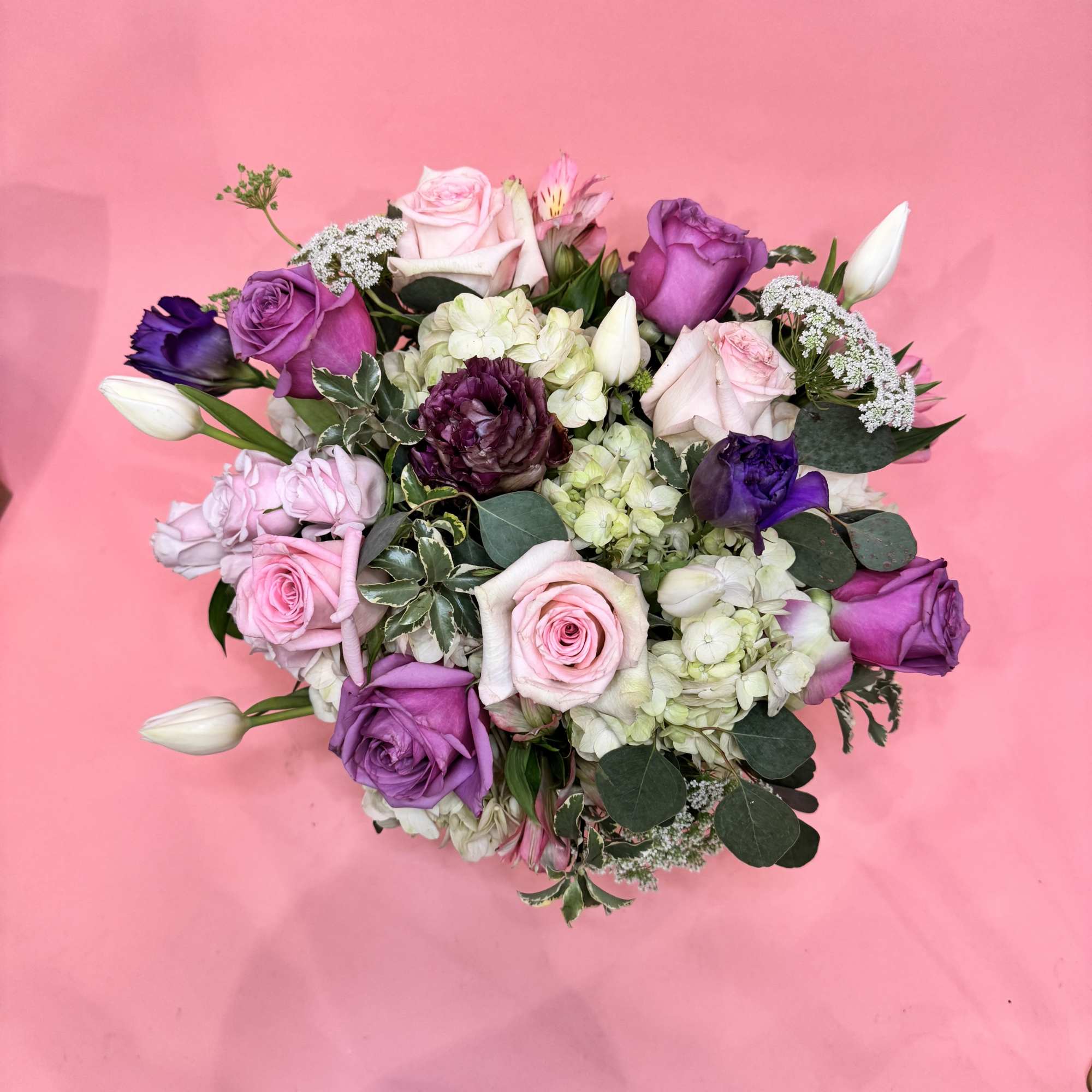 A happy mixture of hydrangeas, roses, lisianthus, and other seasonal pink &amp;
