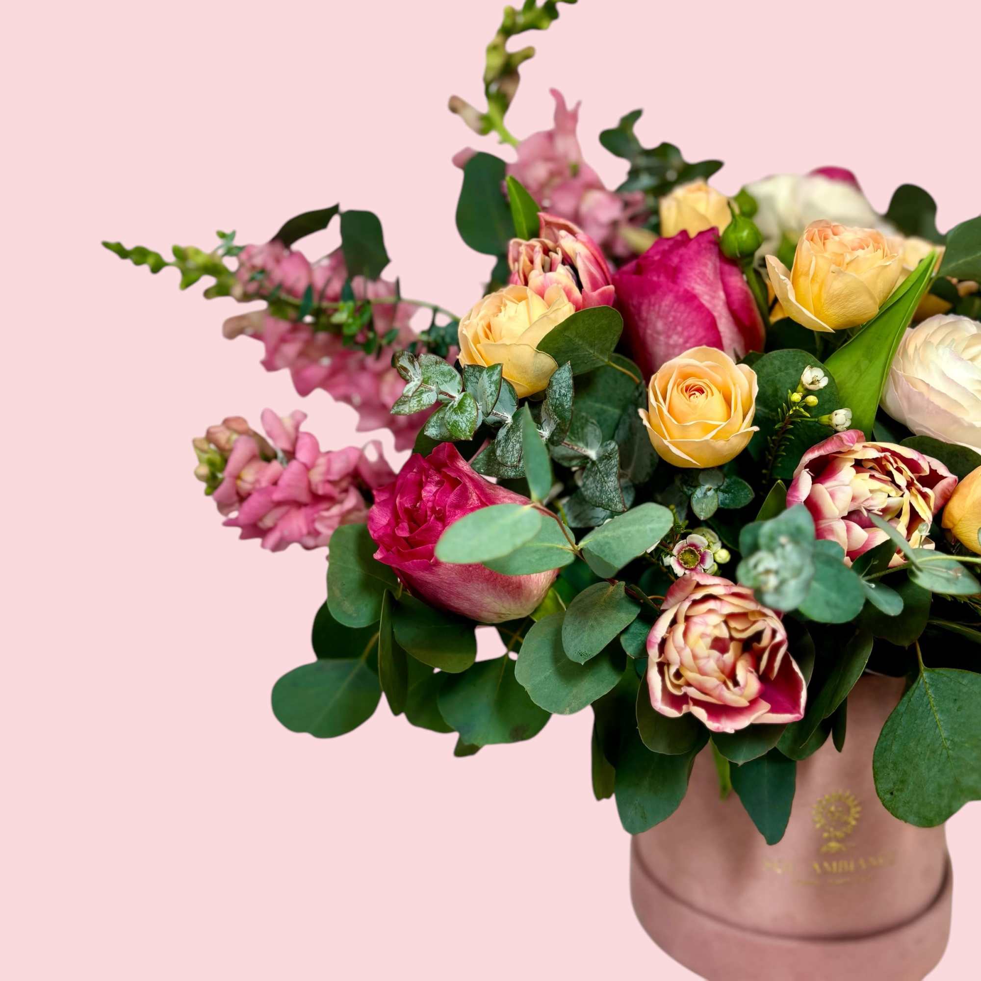 A fun and feminine arrangement of tulips, spray roses, and ranunculus. This