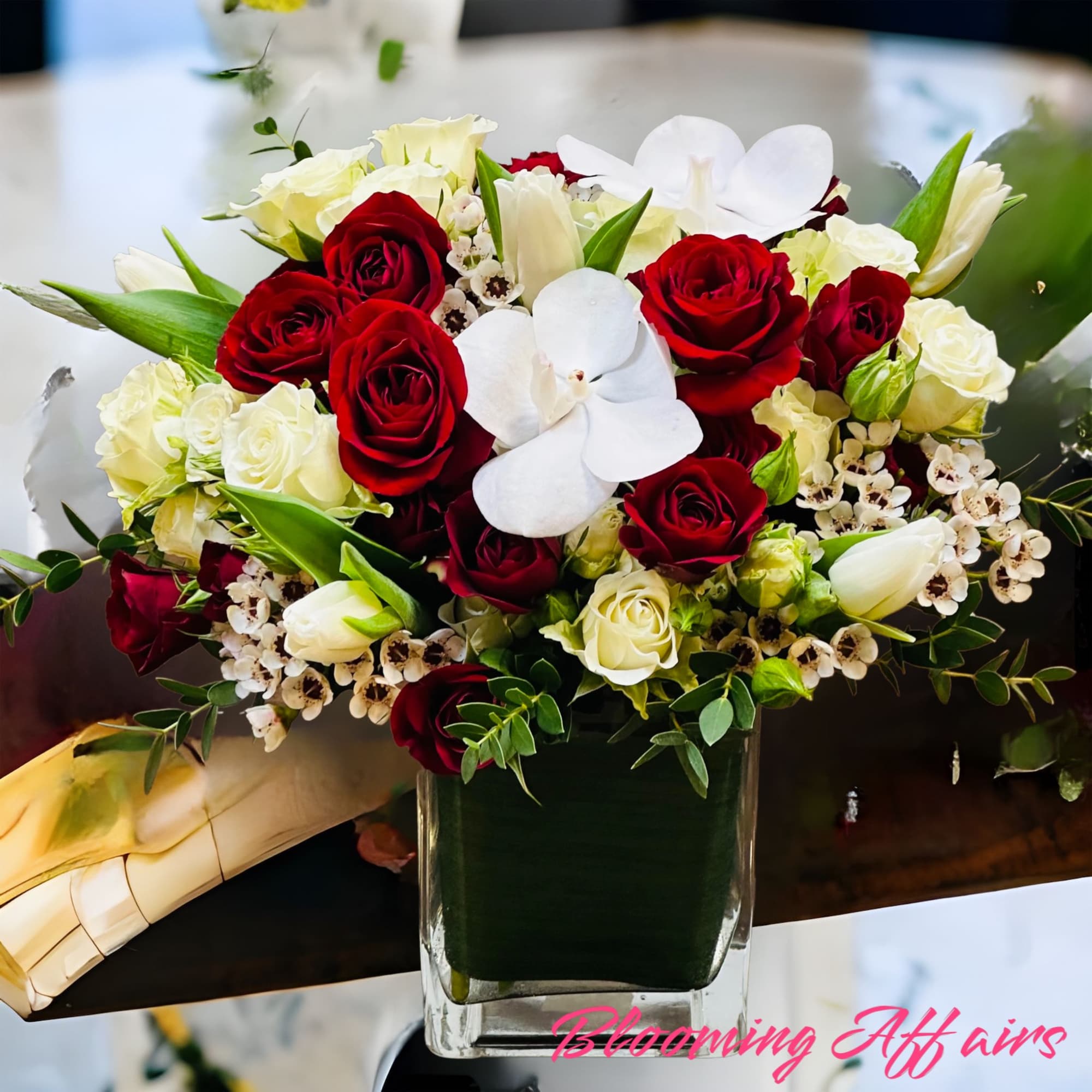 Red and white spray roses, white orchids and tulips.
