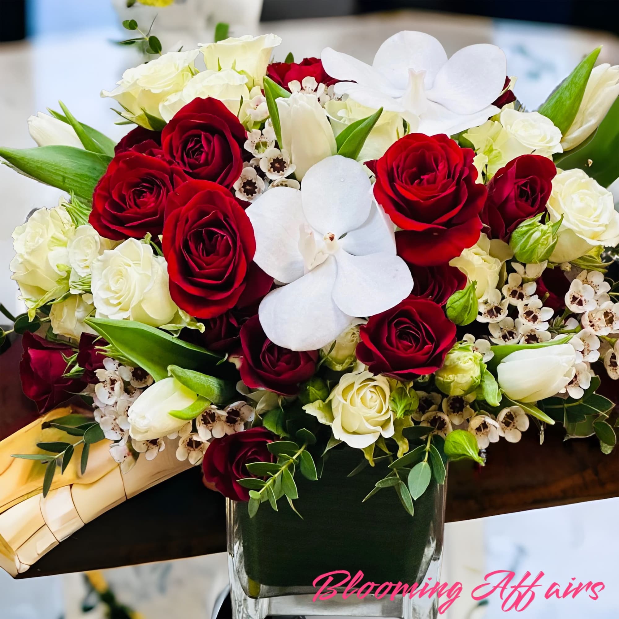 Red and white spray roses, white orchids and tulips.