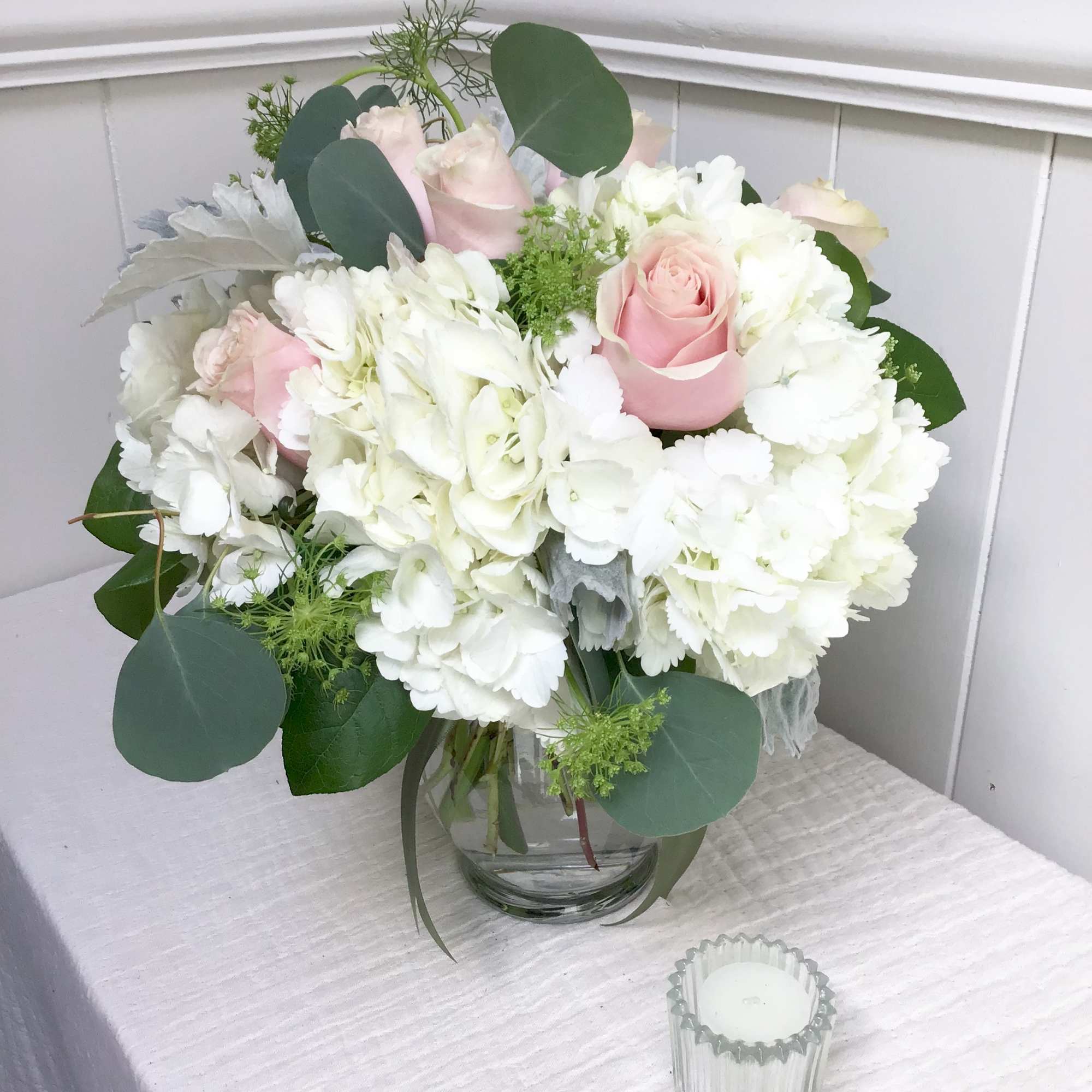 Elegant and timeless: A vase of blush roses and white hydrangea. This