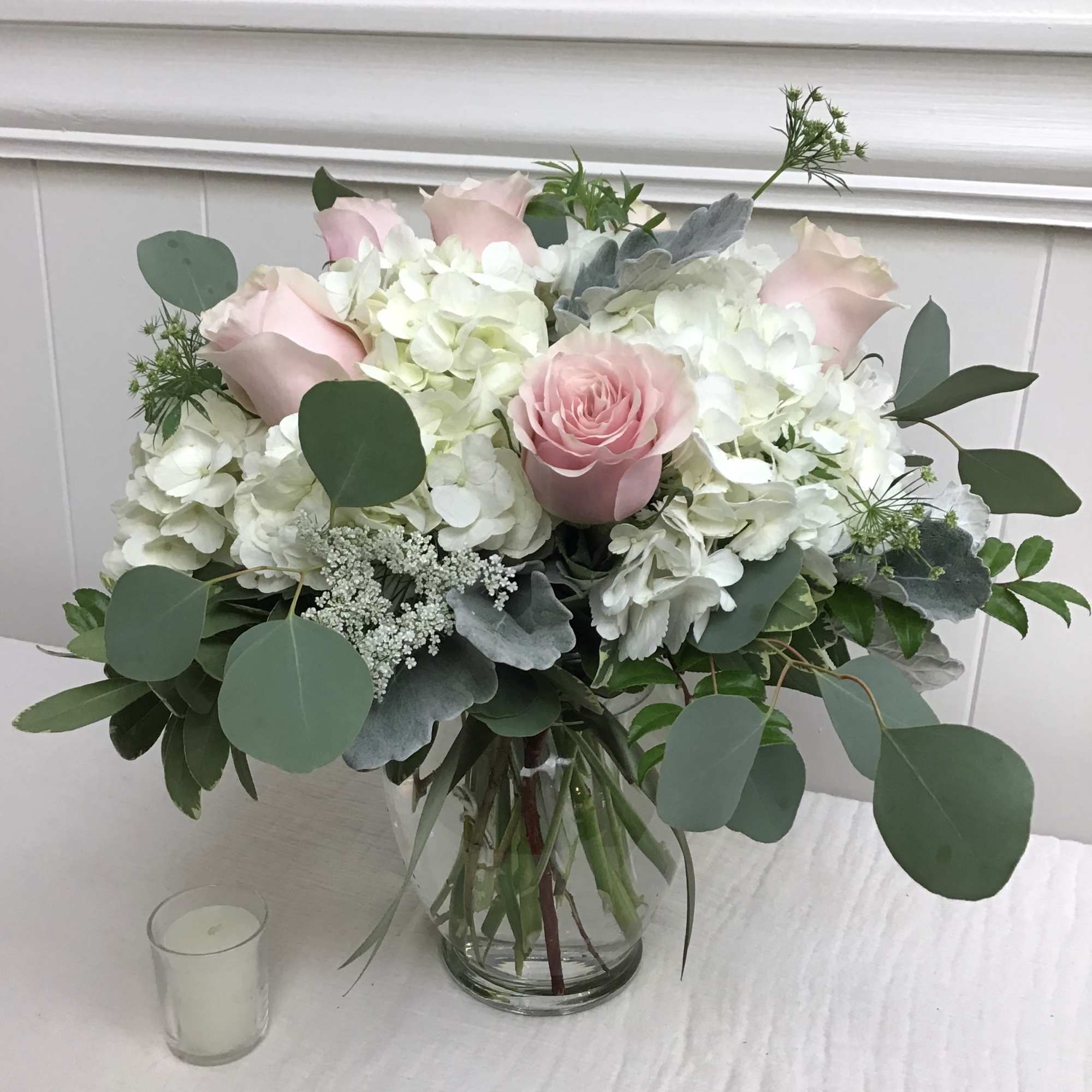 Elegant and timeless: A vase of blush roses and white hydrangea. This