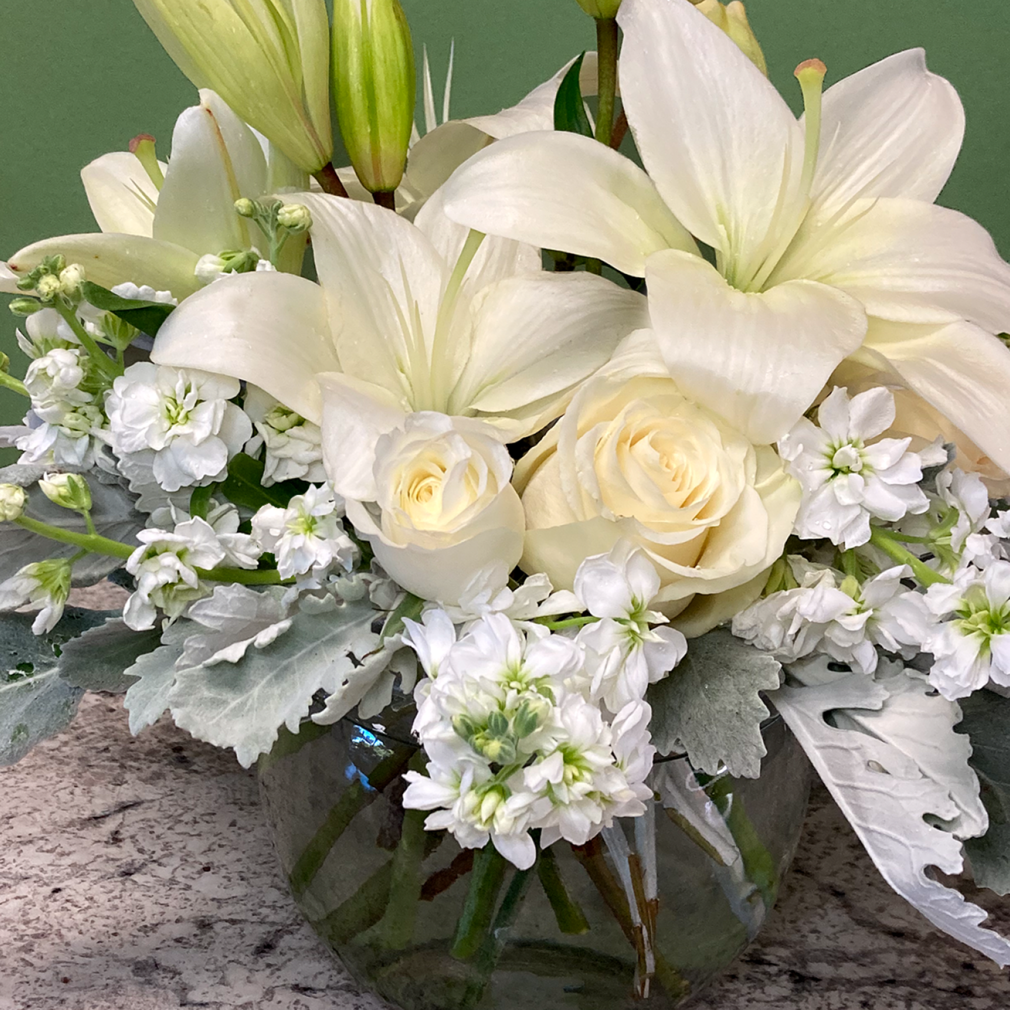A tranquil mixed arrangement that showcases a pristine all-white ensemble of flowers