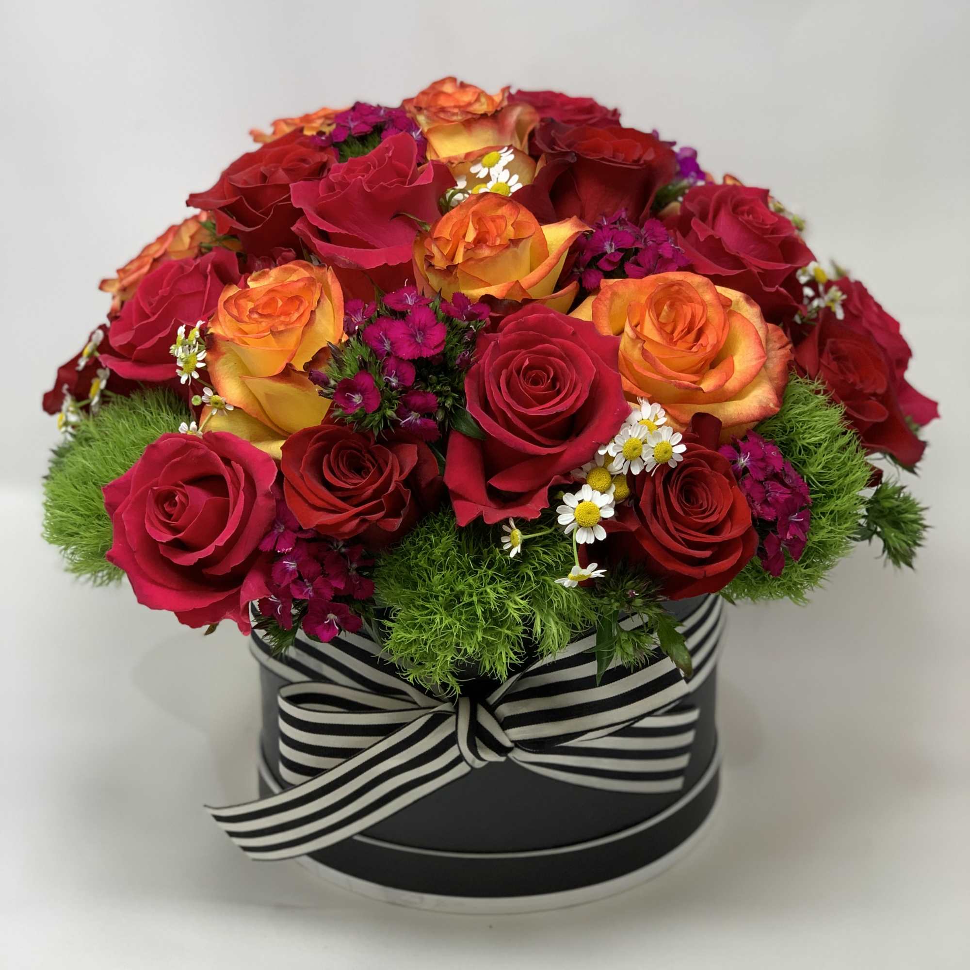 Box of roses with fillers and greens.  Box of roses with fillers and greens.