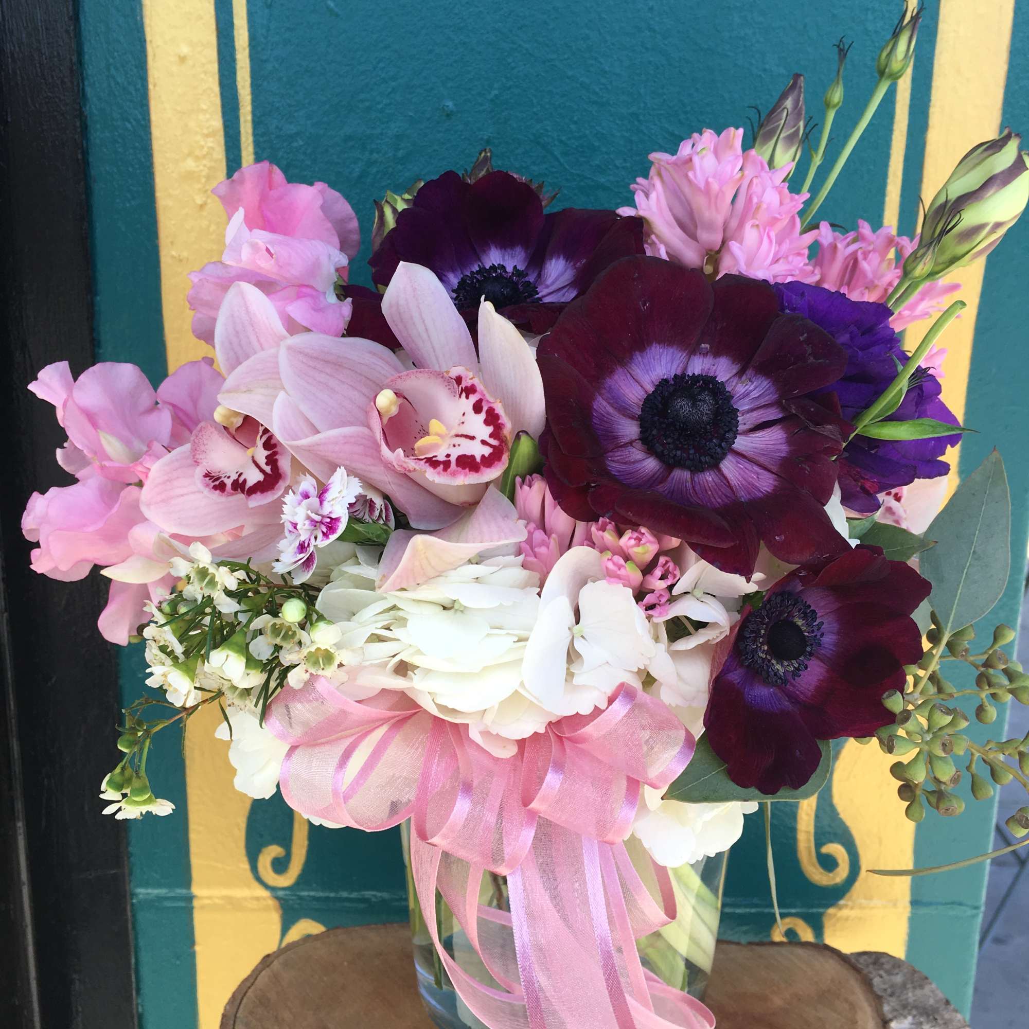 Seasonal purple and pink flowers with white hydrangea arranged into a vase
