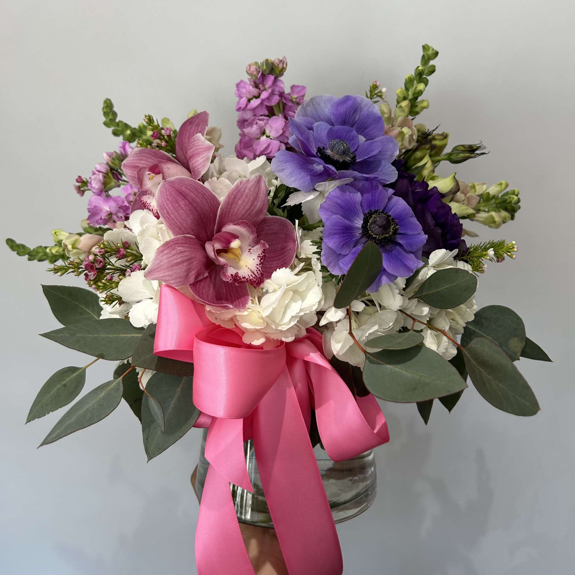 Seasonal purple and pink flowers with white hydrangea arranged into a vase