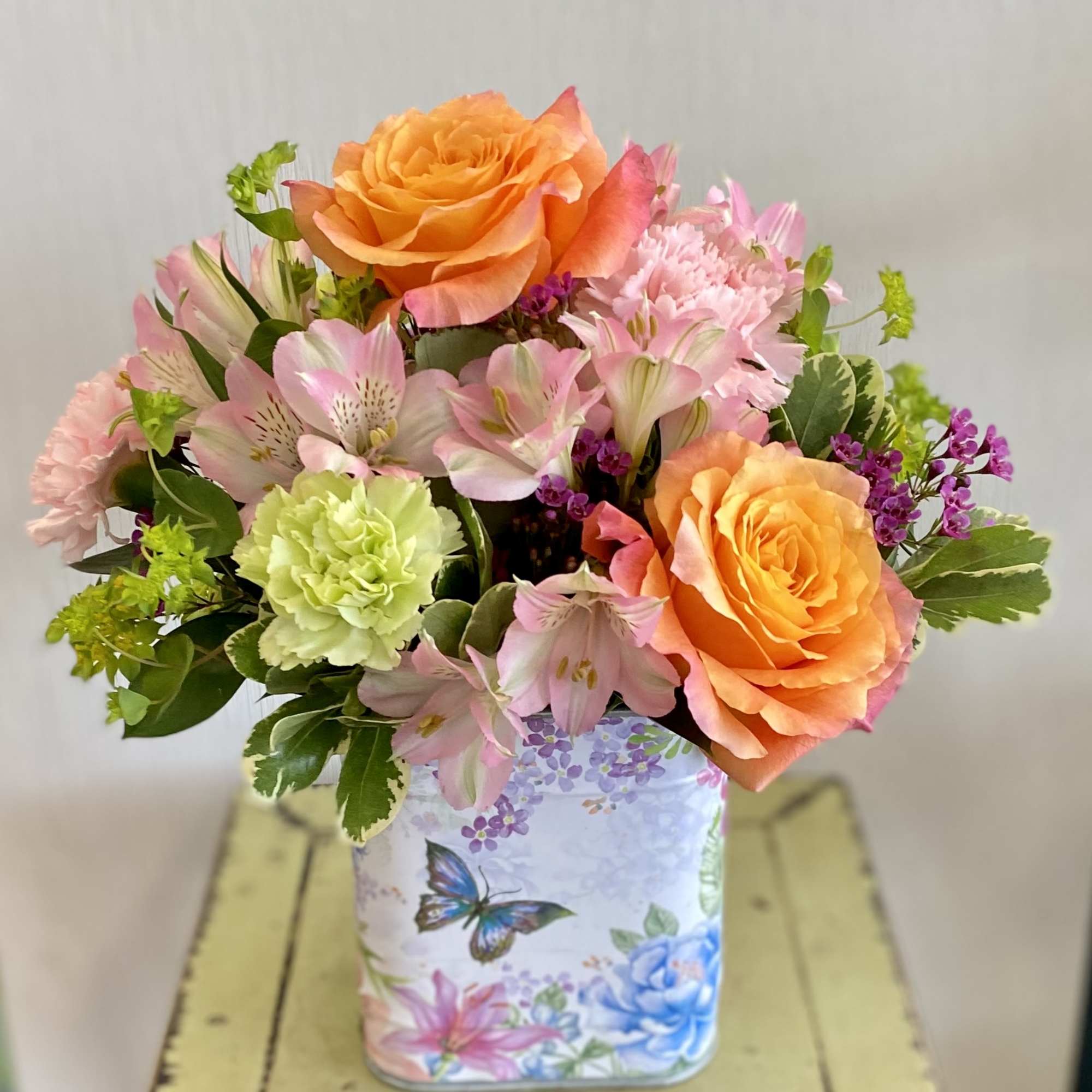 A pretty floral tin bursting with vibrant spring colors. Roses, alstroemerias, and