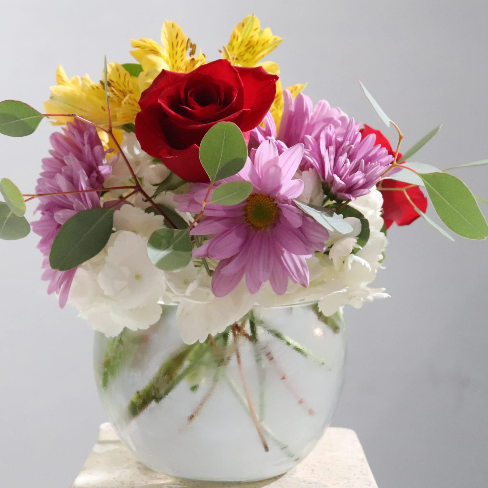 An arrangement with Aspidistra Leaves, Pink Mondial Roses, Alstromeria, and Hydrangea.
