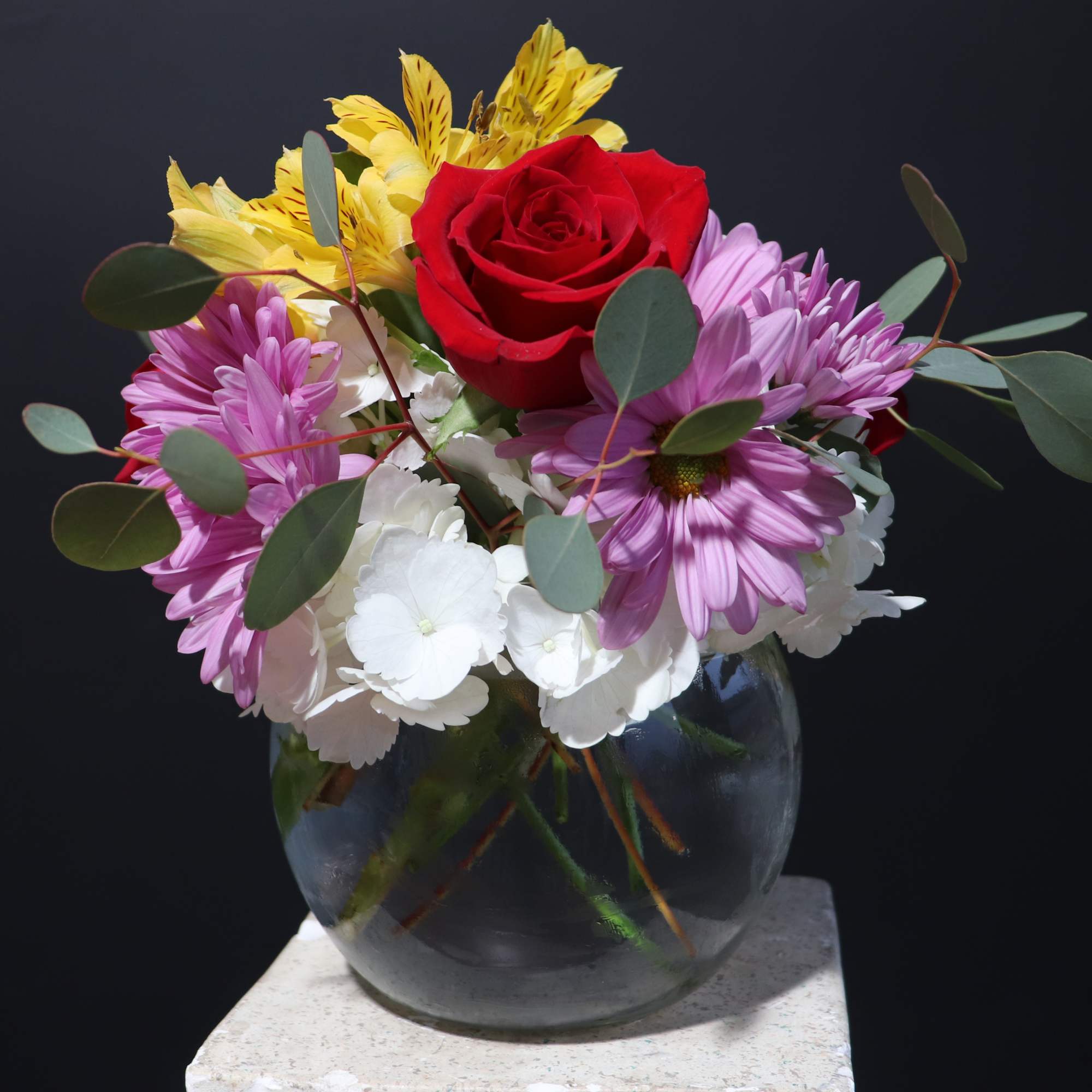 An arrangement with Aspidistra Leaves, Pink Mondial Roses, Alstromeria, and Hydrangea.
